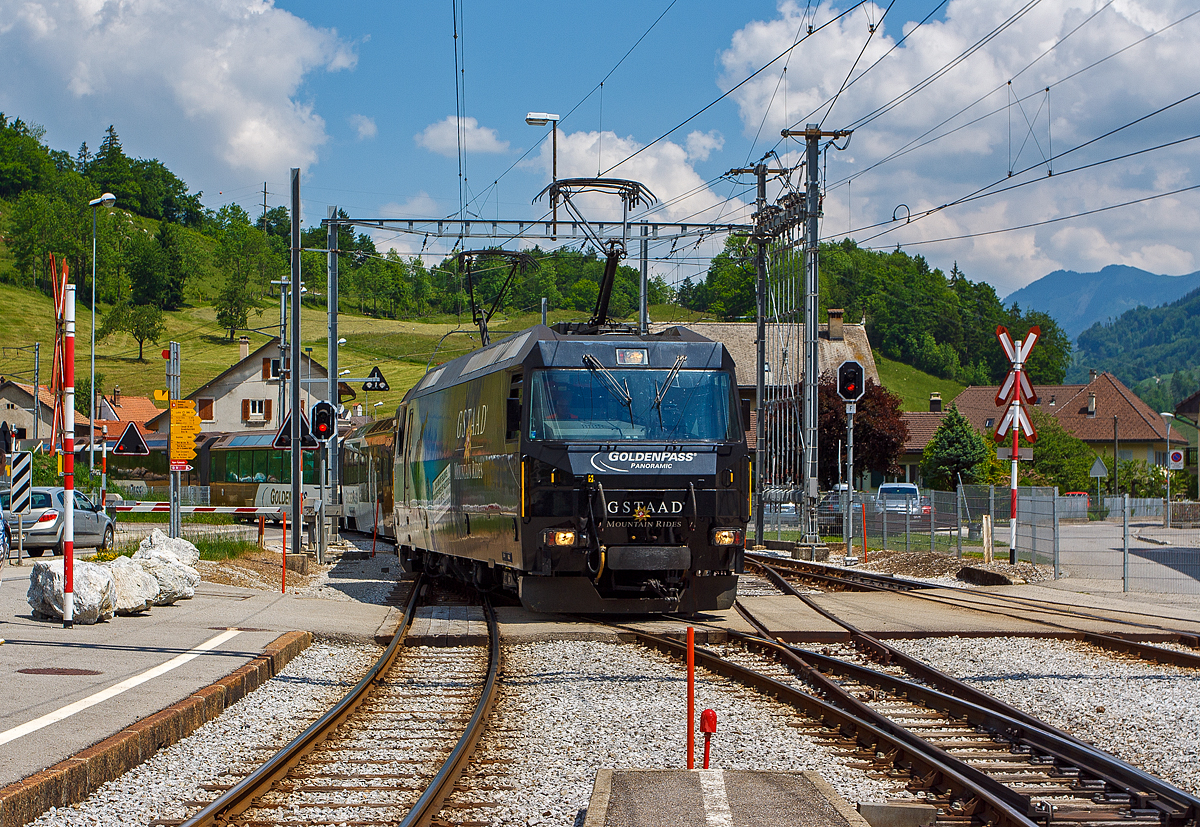 Einfahrt der MOB Ge 4/4 8001 mit dem Golden-Pass-Zug am 28.05.2012 in den Bahnhof Montbovon, mit diesen Zug fahren wir dann nach Zweisimmen. 2012 trug die 8001Werbung f�r die Gstaader Tourismus-Organisation „Gstaad Mountain Rides“.  

Die Lok wurde 1994 von der Schweizerische Lokomotiv- und Maschinenfabrik (SLM) in Winterthur gebaut, die elektrische Ausr�stung ist von ABB Verkehrssysteme AG. Die Ge 4/4 sind die leistungsst�rksten schweizerischen Gleichstrom-Triebfahrzeuge. Die Maschinen der MOB (Montreux–Berner Oberland-Bahn) haben �brigens keine Eigennamen oder Wappen, sie tragen nur die Betriebsnummer. Eine der vier Lok, die Lok 8003 wurde 2019 an die Rh�tische Bahn verkauft und wurde dort zur RhB Ge 4/4 653 umgebaut.

Die vier 1994 von SLM und ABB f�r die MOB gebauten Ge 4/4 �hneln sowohl optisch als auch mechanisch den Ge 4/4 der Bi�re-Apples-Morges-Bahn (BAM) und den Ge 4/4 III der Rh�tischen Bahn (RhB). Der elektrische Teil musste jedoch dem Betrieb ab Fahrleitung mit 900 V Gleichspannung angepasst werden und eine allf�llige Umr�stung auf Zweisystem-Betrieb mit zus�tzlich 15 kV 16,7 Hz ber�cksichtigen. Der Betrieb mit Wechselspannung w�re notwendig gewesen, wenn die GoldenPass-Linie mit einer dritten Schiene bis Interlaken verl�ngert worden w�re. So ist im Lokkasten bereits der Platz f�r einen Transformator f�r den Betrieb bei 15 kV mit 16 2/3 Hz Wechselstrom vorgesehen, ebenso l�sst sich ein dritter Pantograph nachr�sten.

Die Lok ist mit vier Schnellschaltern ausger�stet, die �ber Drosseln die wassergek�hlten Stromrichter versorgen. Die Eingangsspannung der Wechselrichter kann von 630 bis 1080 Volt variieren, f�r den Zweispannungsbetrieb h�tte die Zwischenkreisspannung 1350 Volt betragen. Dies erforderte eine Anpassung der Fahrmotorwicklung gegen�ber den RhB-Loks, die f�r eine Zwischenkreisspannung von 2100 bis 2800 Volt ausgelegt sind. Der mechanische Teil des Fahrmotors ist baugleich mit demjenigen der RhB-Motoren.

Die Loks haben eine Leistung von 2000 kW und erreichen eine H�chstgeschwindigkeit von 120 km/h, die jedoch im Normalbetrieb mangels geeigneter Strecken nicht erreicht wird. Wegen der relativ geringen Spannung sind sehr hohe Stromst�rken erforderlich. Daher fahren die Loks der Montreux–Berner Oberland-Bahn (MOB) immer mit zwei Stromabnehmern am Fahrdraht. Zudem sind die Stromabnehmer mit drei statt den �blichen zwei Schleifleisten versehen, was man hier im Bild auch gut sehen kann.

M�glich ist auch die Vielfachsteuerung mit den MOB GDe 4/4, was erst erforderlich ist, wenn mehr als sechs Panoramawagen zu bef�rdern sind. Dies ist bisher nur vereinzelt vorgekommen.

Die Loks hatten (wie im Bild auch zu sehen) Mittelpuffer mit einer Schraubenkupplung, ab 2017 wurden die drei bei der MOB verbliebenen Loks auf automatische Mittelpufferkupplung (Schwab-Kupplung) umgebaut. Seit 2020 sind die verbliebenen 3 Lokomotiven mit allen Fahrzeugen Steuerwagen sowie den Triebwagen mit Schwab-Automatikkupplung in Vielfachsteuerung kompatibel und

TECHNISCHE DATEN:
Gebaute Anzahl: 4, die Ge 4/4 8003 wurde 2019 an die RhB verkauft. 
Hersteller mech. Teil: SLM, Winterthur 	  	
Elektr. Ausr�stung: ABB Verkehrssysteme AG
Spurweite: 1.000 mm (Schmalspur)
Achsfolge: Bo'Bo'
L�nge �ber Puffer: 16.100 mm 
Treibraddurchmesser: 1.070 mm (neu)
Breite max.: 2.800 mm
H�he : 3.860 mm 	  	
Dienstgewicht: 63 t
Anzahl der Fahrmotoren:  4
Maximale Leistung am Rad:	2.400 kW 	 
Dauerleistung am Rad: 2.000 kW 	  	 
Dauerzugkraft am Rad: 150 kN
Anfahrzugkraft am Rad:  200 kN
H�chstgeschwindigkeit: 120 km/h 	  
Anh�ngelast bei 45 km/h und 73‰ Steigung: 170 t
Anh�ngelast bei 80 km/h und 25‰ Steigung:	300 t
Stromsystem: 900 V DC (Gleichstrom)
Strom�bertragung: 2 Einholmstromabnehmer mit je 3 Schleifleisten

