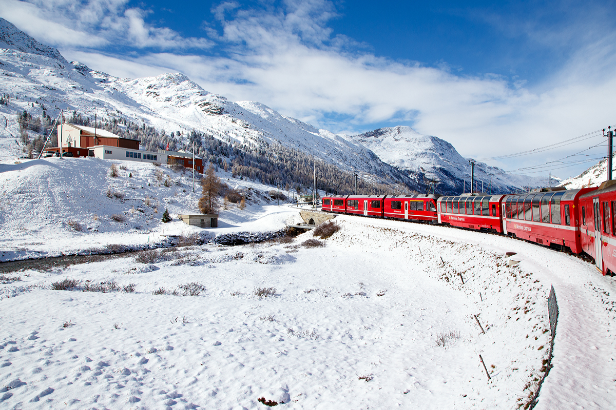 
Geführt von dem ALLEGRA-Zweispannungstriebzug RhB ABe 8/12 – 3501 „Willem Jan Holsboer „ erreicht am 04.11.2019  unser RhB Regionalzug von Tirano nach St. Moritz, nun Haltestelle Bernina Diavolezza. 
Links die Talstation (2.096 m ü. M.) der Kabinenseilbahn Diavolezza (Teufelin).
