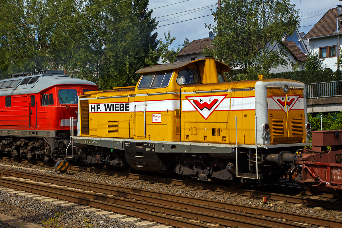 Geschleppt von der Ludmilla 234 278-0 wird die Wiebe Lok 2 bzw. 211 341-3 (92 80 1211 341-3 D-BLP), ex DB 211 341-3, ex DB V 100 1341, am 24.07.2020 von Kreuztal in Richtung Hagen. 

Die V 100.10 wurde 1962 von Arnold Jung Lokomotivfabrik GmbH, Jungenthal bei Kirchen an der Sieg, unter der Fabriknummer 13468 gebaut und als V 100 1341 an die Deutsche Bundesbahn geliefert. Zum 01.01.1968 erfolgte dann die Umzeichnung in DB 211 341-3, als diese fuhr sie bis zur Ausmusterung 1988. Im Jahr 1990 ging sie an die H. F. Wiebe KG, wo sie erst als Lok 1 geführt wurde.
Die V100.10  (BR 211) haben eine12-Zylinder-Viertakt-Dieselmotor  mit etwas geringerer Leistung gegenüber der V 100.20. Da die V 100.10 (BR 211) für den leichten Reise- und Güterzugdienst auf Nebenstrecken vorgesehen war. Bei den V 100.10 kam überwiegend der Maybach MD 650 1B und der Daimler-Benz MB 820 Bb zum Einsatz, seltener war der MAN L 12 V 18/21 zu finden. Die Nennleistung lag bei 809 kW (1100 PS).

TECHNISCHE DATEN:
Spurweite: 1.435 mm
Achsfolge: B'B'
Eigengewicht: 63,0 t
Länge über Puffer: 12.300 mm
Drehzapfenabstand: 6.000 mm
Achsstand im Drehgestell: 2.200 mm
größte Breite: 3.115 mm
größte Höhe über Schienenoberkante: 4.275 mm
kleinster befahrbarer Gleisbogen: 100 m
Treibraddurchmesser: 950 mm
Höchstgeschwindigkeit: 100 km/h
Antrieb: dieselhydraulisch
Leistung: 809 kW (1.100 PS)
Nenndrehzahl: 1.500 U/min
Anfahrzugkraft: 177 kN
Kraftübertragung: hydraulisch
Kupplungsart: Schraubenkupplung
