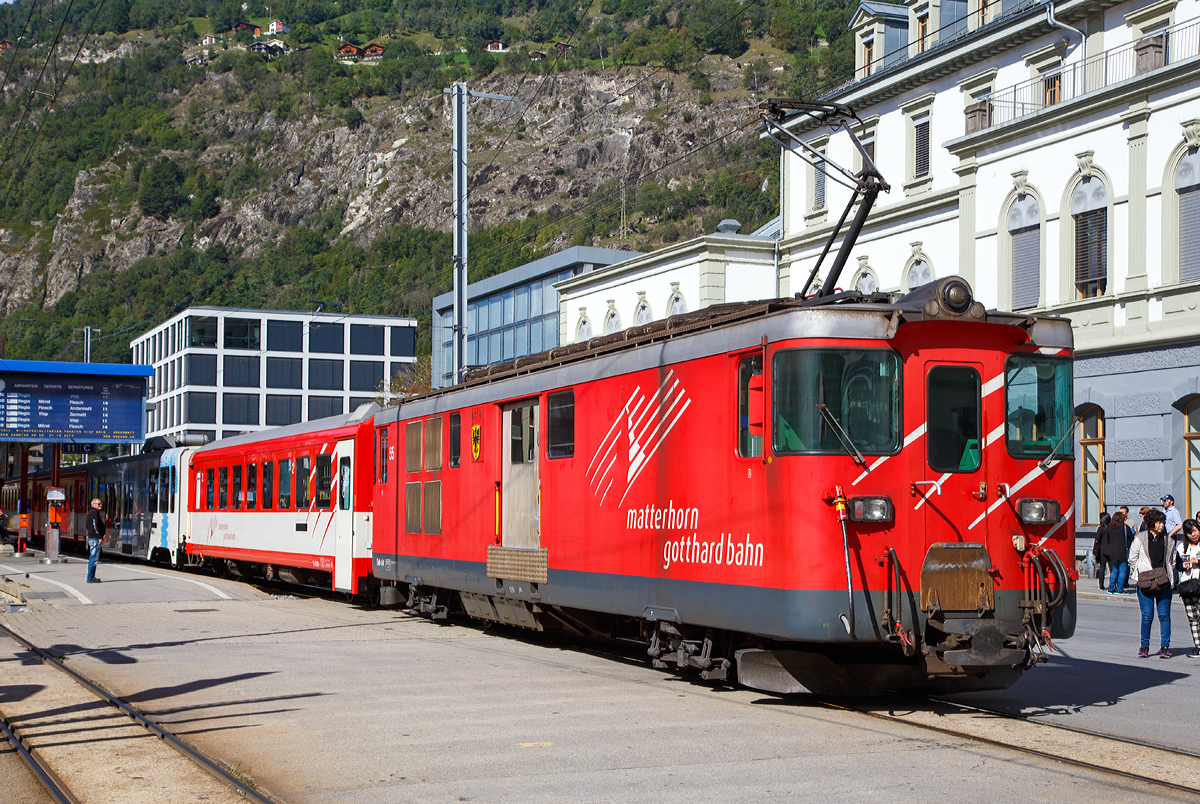 
Geschoben von dem elektrischen Zahnradtriebwagen Deh 4 /4 – 55 „Brig“ erreicht der MGB Regionalzug von Andermatt am 16.09.2017 den Bahnhof Brig.

Der Gepäcktriebwagen wurde 1972 gebaut, der Lokomotivkasten ist von SIG, die Triebdrehgestelle von SLM und die elektrische Ausrüstung von BBC.

Da das Rollmaterial in den 60er Jahren großenteils veraltet und der Verkehr in der Wintersaison stark angestiegen war, benötigte die FO dringend leistungsfähigere Triebfahrzeuge. Man entschied sich für leistungsfähige Gepäcktriebwagen, die freizügig auf dem gesamten Netz eingesetzt werden konnten. Die fünf Fahrzeuge des Typs Deh 4/4 wurden 1972 bestellt und lösten die HGe 2/2 und die ABDeh 2/4 ab, die den Wintersportverkehr auf der Schöllenenbahn nicht mehr bewältigen konnten. 

Ein Nachbau der FO-Deh 4/4 erhielt einen völlig andersartigen Kasten, weshalb diese Fahrzeuge bei der FO als Deh 4/4 I und II unterschieden wurden. Seit der Fusion zur MGB ist diese Bezeichnung nicht mehr gebräuchlich, die MGB unterscheidet die Serien nach den Nummernbereichen 21, 51 und 91. Wobei sie sich schon optisch und auch technisch etwas unterscheiden.

Technische Daten Deh4/4 I (51-55):
Spurweite: 1.000 mm
Achsformel: Bo'zz Bo'zz
Länge über Puffer: 16.900 mm
Größte Breite: 2.650 mm
Größte Höhe (bei abgesenkten Stromabnehmer): 3.880 mm
Leergewicht: 48,3  t 
Dienstgewicht: 50,3 t
Maximale Zuladung: 2,0 t
Höchstgeschwindigkeit: Adhäsion 60 km/h / Zahnstange 30 km/h
Stundenleistung: 1.032 kW
Dauerleistung: 936 kW
Treibraddurchmesser:  790 mm (Adhäsion) / 688 mm (Zahnrad)
Stromsystem: 11 kV 16,7 Hz AC
Anzahl der Fahrmotoren: 4
Größe der Ladefläche: 11,5 m2
