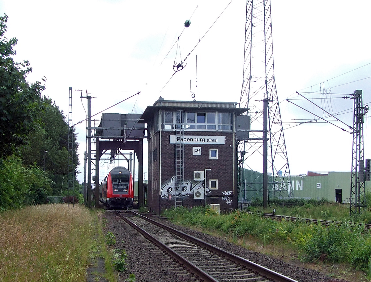 
Gleich vor dem Bahnhof Papenburg (Ems) befindet sich die Eisenbahnklappbrücke über den Papenburger Sielkanal, davor noch das Fahrdienstleiterstellwerk Papenburg (Ems) „Pf“, hier am 20.06.2009.

Die beiden Brückenteile sind nun unten und der RE kann den Bahnhof anfahren.