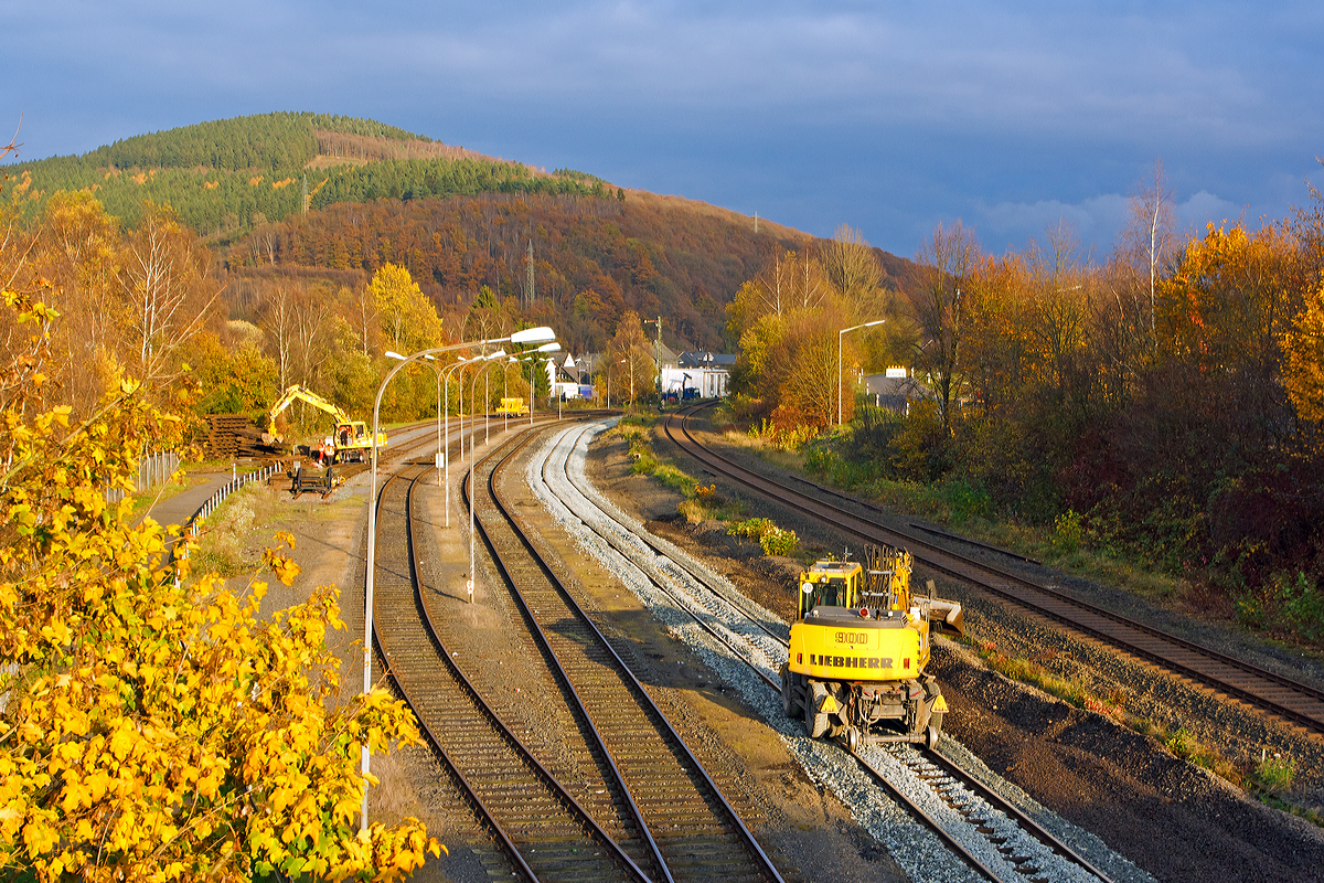 Gleisbaustelle auf den Rangierbahnhof der KSW Kreisbahn Siegen-Wittgenstein (ehem. Freien Grunder Eisenbahn AG) in Herdorf, hier am 06.11.2014. Das Hauptgleis ist schon erneuert, der eine Liebherr A 900 C ZW Li / 1031 Zweiwegebagger planiert noch den Bereich neben dem Gleis, während ein weiterer die Eizelteile vom Altgleis separiert.