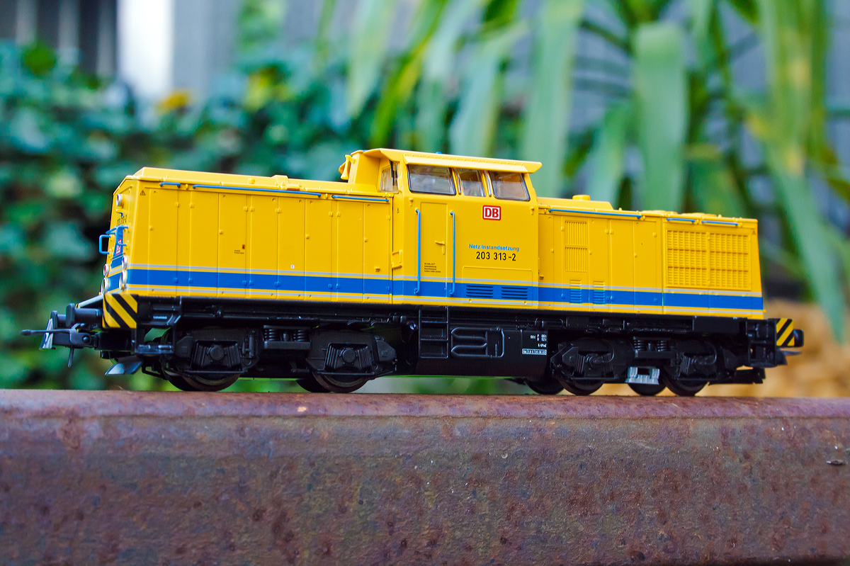 
H0 (1/87) Roco Modell (62945) von der 203 313-2 der DB Netz AG auf original gro�er Schiene, am 11.09.2014 in Herdorf.  

Das Vorbild: 
Die V 100.1 wurde 1975 bei LEW (VEB Lokomotivbau Elektrotechnische Werke „Hans Beimler“, Hennigsdorf) unter der Fabriknummer 15097  gebaut und als 110 825-7 an die DR ausgeliefert. 
1984 erfolgte der Umbau und Umzeichnung in DR 112 825-5, die Umzeichnung in DR 202 825-6 erfolgte 1992 und ab 01.01.94 dann DB 202 825-6, die Ausmusterung bei der DB erfolgte 2000 und ging dann an SFZ - Schienenfahrzeugzentrum Stendal (heute ALS - ALSTOM Lokomotiven Service GmbH, Stendal), hier erhielt sie einen neuen CAT-Motor und wurde entsprechend in 203 313-2 umbezeichnet. Im Jahr 2003 ging sie dann an die DB Bahnbau und 2004 an die DB Netz AG.
