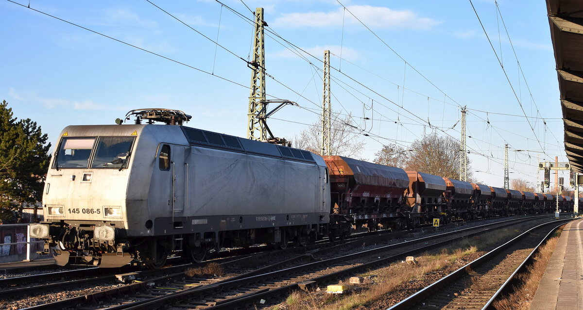 HANSE Bahn Nord GmbH mit ihrer  145 086-5  [NVR-Nummer: 91 80 6145 086-5 D-HANSE] und einem Schotterzug (leer) am 03.03.26 Höhe Bahnhof Magdeburg-Neustadt.