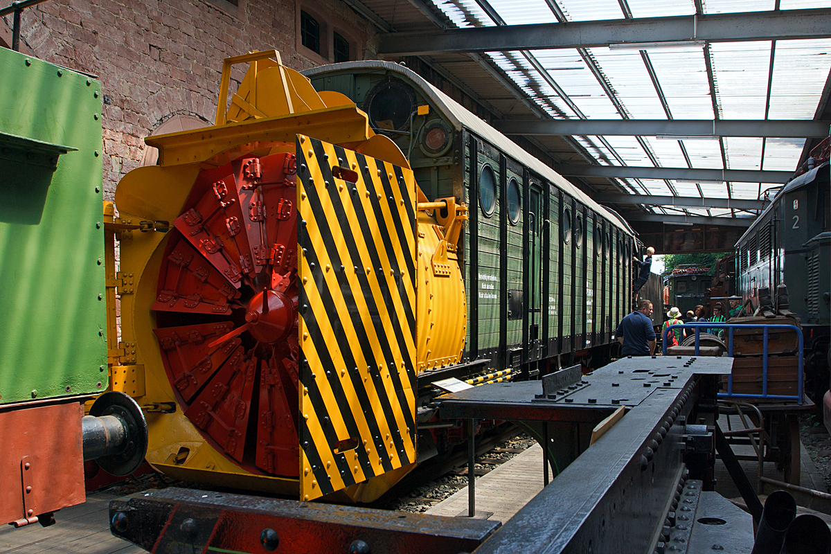 
Henschel-Dampfschneeschleuder ex 30 80 DB 947 5 160-6 Schneeschleuder 834, ex Wpt 6410, am 31.05.2014 im DGEG Eisenbahnmuseum Neustadt/Weinstra�e (Pfalzbahn - Museum). 

Die Schneeschleuder wurde 1942 bei Henschel & Sohn unter der Fabriknummer 27149 gebaut. Diese Schneeschleudern haben keinen eigenen Antrieb, die Leistung des Dampfkessels wurde voll und ganz f�r den Antrieb des gro�en Schleuderrades ben�tigt. Sie wurde daher von einer oder mehreren Schublokomotiven bewegt und gegen den Schnee gedr�ckt.  

Die mit den Baujahren 1941/42 herausgebrachten Schneeschleudern stellten die Fortentwicklung der Vorlieferung dar. Damit die Schneeschleuder auch auf Strecken f�r geringeren Achsdruck (bis zu 13 t) eingesetzt werden konnte, wurde 1941/42 die sechsachsige Bauart als Einheitsbauart eingef�hrt. Sie war mit einer stehenden Vierzylinder-Dampfmaschine als Antriebsorgan f�r das Schleuderrad ausger�stet, welche seinerzeit von der Firma Schichau, Elbing, entwickelt wurde.  

Jede Schneeschleuder bestand aus folgenden Hauptteilen:
2 dreiachsige Drehgestelle, deren vorderes zus�tzlich den Eisbrecher tr�gt,
Hauptrahmen, mit Wagenkastenaufbau, an dessen vorderem Ende sich das Schleuderradgeh�use befindet,
Dampfkessel mit Speisevorrichtungen und allen notwendigen Armaturen,
Dampfmaschine zum Antrieb des Schleuderrades,
Drucklufterzeugungsanlage f�r die Bet�tigung der Seitenfl�gel, Bodenschaufel und Eisbrecher,
Schneer�umger�te (Schleuderrad, Seitenfl�gel, Bodenschaufel, Eisbrecher),
Luftdruckbremse, Tender.


Technische Daten der Schneeschleuder:
Spurweite: 1.435 mm
L�nge �ber Puffer: 22.300 mm
Drehzapfenabstend: 16.800 mm
Raddurchmesser: 850 mm
Gr��te H�he : 4.250 mm
Gr��te Breite:  3.130 mm
Dienstgewicht: 64 t (ohne Tender)
H�chstgeschwindigkeit: 65 km/h
Schleuderraddurchmesser: 2.900 mm
Schleuderraddrehzahl: 120 - 160 U/min
Dampfmaschine: 4 Zylinder, stehend
Zylinderdurchmesser: 280 mm
Kolbenhub: 280 mm
Umlaufzahl: 500 - 550 U/min
Gewicht der Dampfmaschine einschl. Zahnradvorgelege und Schleuderradwelle 10.730 kg
Das Drehmoment der Kurbelwelle wurde durch ein Stirnradvorgelege (�bersetzung 1:3,3) auf die Schleuderradwelle �bertragen. 
Die Leistung der Dampfmaschine betrug ca.: 700 PS.
Kessel�berdruck: 13 bar
Tender: 2´2´T26 
Tendergewicht: 49 t 
Wasservorrat: 26 m� 
Kohlevorrat: 8 t
