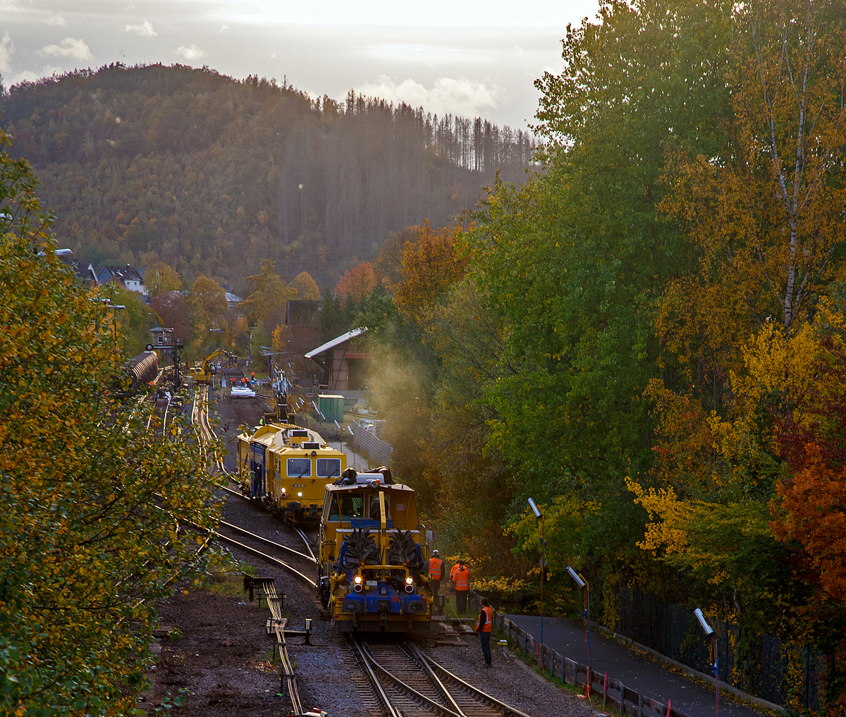 
Herdorf den 27.10.2020:
Das Gleis ist wieder frei, nun geht es für die P&T Schotterverteil- und Planiermaschine SSP 110 SW (Schweres Nebenfahrzeug Nr. D-DGU 99 80 9425 068-0) und die P&T Universalstopfmaschine UNIMAT 09-475/4S (Schweres Nebenfahrzeug Nr. D-DGU 99 80 9424 001-2) der DGU wieder zurück nach Neunkirchen (Siegerland). Von dort aus werden sie das Gleisbett im 3. Durchgang nochmals durch arbeiten. Da die beiden Maschinen nur eine Arbeitsrichtung haben, müssen sie zwangsläufige wieder zum Ausgangspunkt  zurück.

Das Gleis (Ober- und Unterbau) der Hellertalbahn (KBS 462) wurde zwischen Herdorf und Neunkirchen komplett erneuert. Nachdem der Oberbau auf der Strecke fertig war, wurde die Weiche zum Anschluss der KSW (im unteren Bildrand) erneuert und danach hat man diese Woche damit begonnen das Gleis 1 im Bahnhof Herdorf komplett zu erneuern (Ober- und Unterbau).