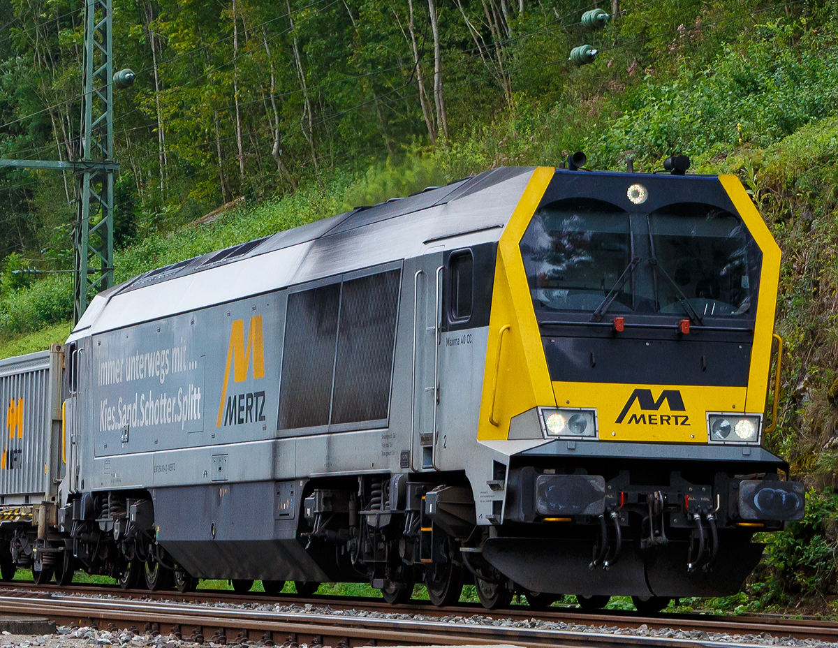 
Hier nochmal als Portrait... 
Die Voith Maxima 40CC der Heinrich Mertz Kies- u. Sandwerke, die 264 013-4 (92 80 1264 013-4 D-MERTZ), fährt am 09.09.2017 mit ihrem Kieszug (20´Container mit Kies) durch Horb in Richtung Singen.

Die Voith Maxima 40 CC wurde 2009 von Voith in Kiel unter der Fabriknummer L06-40041 gebaut.

Die Maxima-Familie war die erste Lokomotiventwicklung der Voith Turbo Lokomotivtechnik GmbH. Der erste Typ dieser Familie war die Maxima 40 CC, die erstmals auf der Innotrans 2006 in Berlin vorgestellt wurde. Zwei Jahre später folgte die Maxima 30 CC, die ihrer größeren Schwester weitgehend gleicht, jedoch einen Dieselmotor mit weniger Leistung besitzt.

Bei den beiden Typen handelt es sich um schwere sechsachsige Lokomotiven für den Güterzugdienst. Für den Antrieb kommen mittelschnell laufende Dieselmotoren von ABC zum Einsatz. Die Leistungsübertragung erfolgt über das neu entwickelte Voith-Getriebe des Typs LS 640 breU2, das unter dem Produktnamen Turbo Split vermarktet wird. Dieses Getriebe besitzt je zwei Wandler mit nachgeschalteter Wendestufe für die beiden Drehgestelle. Dabei handelt es sich im Prinzip um zwei Getriebe in einem Gehäuse, die von einer gemeinsamen Antriebswelle aus angetrieben werden, jedoch über zwei voneinander entkoppelte Abtriebe die beiden Drehgestelle der Lokomotive antreiben.

Entsprechend ihrer Verwendung als schwere Streckenlokomotive können die Maxima in verschiedenen europäischen Ländern zugelassen werden. Unter den ersten Lokomotiven befinden außer für Deutschland auch Varianten für die Niederlande, Belgien, Tschechien und Polen. Dabei sind Lokvarianten mit Ausrüstungen für bis zu vier unterschiedliche Länder lieferbar.


Technische Daten:
Spurweite: 1.435 mm
Achsfolge: C'C'
Länge über Puffer: 23.200 mm 
Drehgestellmittenabstand: 11.430 mm
größte Breite: 2.900 mm
Raddurchmesser (neu): 1.150 mm
kleinster bef. Gleisbogen: 80 m 
Dienstgewicht: 135 t
Kraftstoffvorrat: 9.000 l  
Höchstgeschwindigkeit: 120 km/h Streckengang 

Motorhauptdaten:
Motorbauart: Mittelschnellläufer V16-Zylinder-4 Takt-Dieselmotor  mit Turbolader und Ladeluftkühlung
Motorhersteller: ABC (Anglo Belgian Corporation)
Motortyp:   16 DZC-1000-169-A 
Nennleistung:  3.600 kW (4.890 PS)
Drehzahl :  1.000  U/min   
Bohrung/Hub: 256/310 mm
Hubraum: 255,2 Liter l
Abgas-Emission :   EU Nonroad Richtlinie 97/68 EG, Stufe IIIA 
Länge: 5.290 mm
Breite: 1.850 mm
Höhe: 2.840 mm
Gewicht (trocken): ca. 21.750 kg

Getriebe und Leistungsübertragung:
Hydrodynamisches-Voith-Getriebe vom Typ LS 640 reU2  Turbosplit 
betriebliche Anfahrzugkraft: 408 kN (max. 519 kN)
dynamische Dauerbremsleistung: 2.500 kW