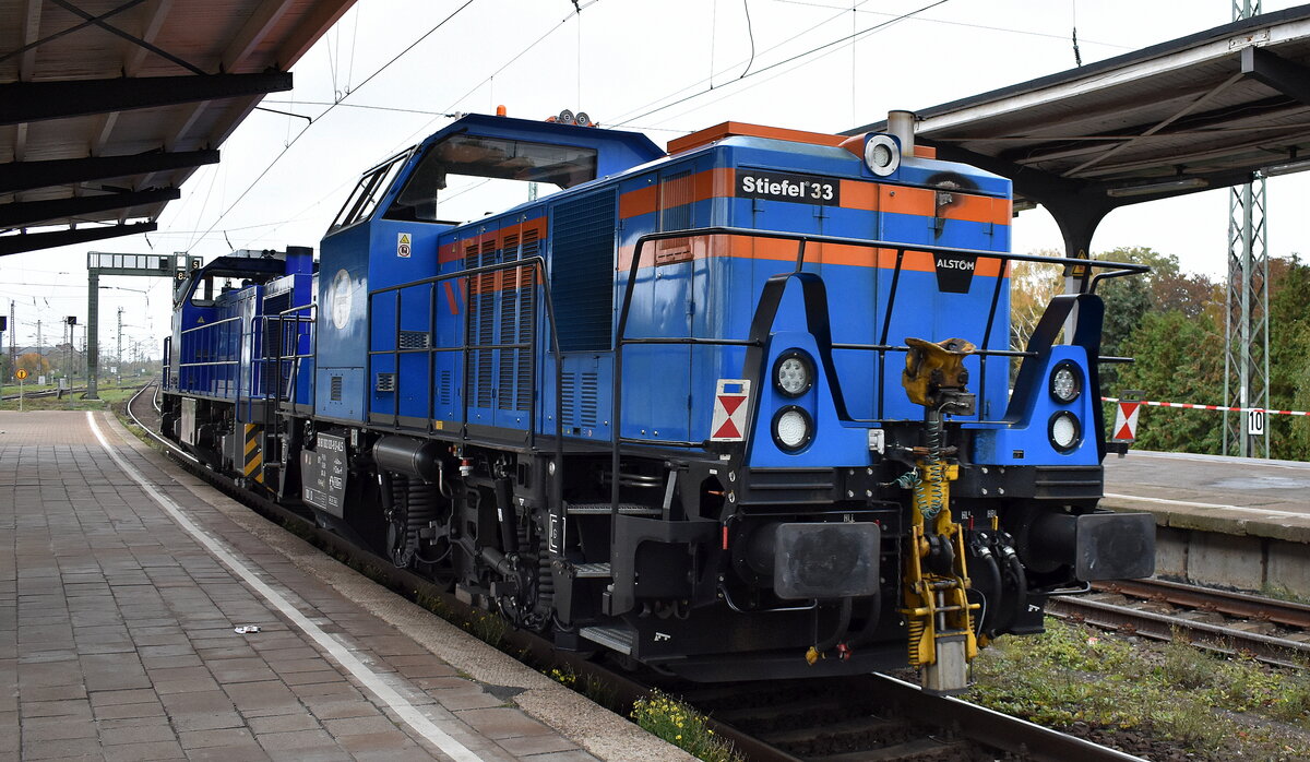 Hybridlok der Hanseatisches Bahn Contor GmbH der Prima H3 Name:  Stiefel 33  (NVR.  90 80 1002 033-1 D-HBC ), seitlich stand an der T�r  skw Piesteritz 3  die wohl in Lutherstadt Wittenberg als Werklok zum Einsatz kommen wird, am Haken von  IL - InfraLeuna GmbH, Leuna [D] Lok  211  [NVR-Nummer: 92 80 1275 014-9 D-LEUNA] bei der �berf�hrung am 29.10.26 Durchfahrt Bahnhof Magdeburg Neustadt.