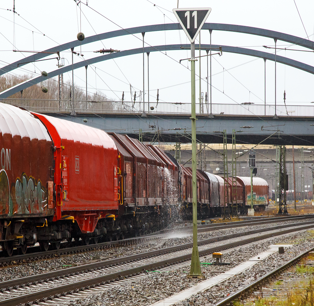 
Impression bei Regen....
Das Wasser läuft im Weichenbereich von einem Drehgestellflachwagen mit sechs Radsätzen, verschiebbaren Teleskophauben und Lademulden für Coiltransporte der Gattung Sahimms-u ab.
Kreuztal den 08.12.2018
