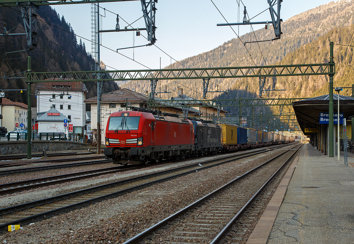 In Doppeltraktion, wobei gerade mit gesenkten Stromabnehmern ausrollend, haben zwei Siemens Vectron MS mit einem KLV-Zug, aus �sterreich kommend, den Bahnhof Brenner (Stazione di Brennero) erreicht. Vorne die 193 311 (91 80 6193 311-8 D-DB) der DB Cargo und dahinter die an die Mercitalia Rail S.r.l. vermietete X4 E – 704 / 193 704 (91 80 6193 704-4 D-DISPO) der MRCE Dispolok GmbH (M�nchen). Nach den Formalit�ten und dem Wechsel vom Lokf�hrer, werden sp�ter die Stromabnehmer (f�r 3 kV DC), nun unter dem italienischen 3 kV Gleichstrom, angehoben und die weitere Fahrt in Italien kann fortgesetzt werden.

Beide Siemens Vectron MS wurde 2018 von Siemens in M�nchen-Allach gebaut, die DB 193 311 unter der Fabriknummer 22452 und die MRCE 193 704 unter der Fabriknummer 22388. Diese Vectron Lokomotiven sind als MS – Lokomotive (Multisystem-Variante) mit 6.400 kW konzipiert und zugelassen f�r Deutschland, �sterreich, Schweiz, Italien und Niederlande (D/A/CH/I/NL), Die DB Vectron ist f�r eine H�chstgeschwindigkeit von 200 km/h und die MRCE Vectron ist f�r eine H�chstgeschwindigkeit von160 km/h zugelassen.