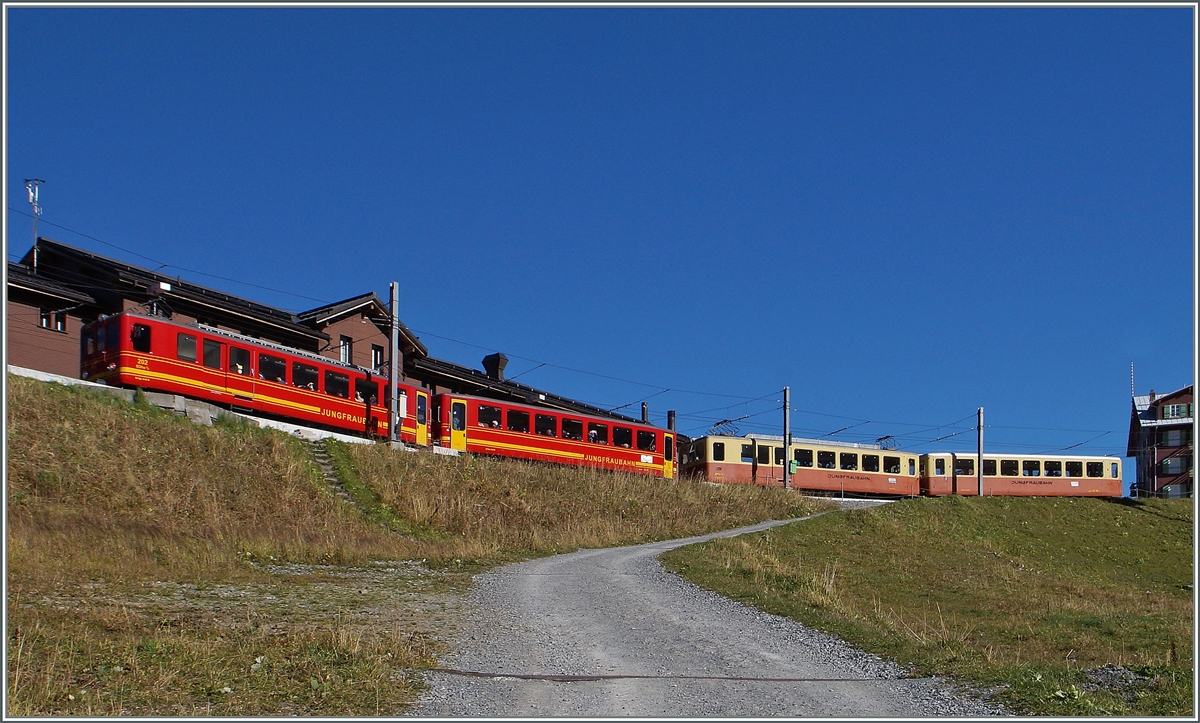 Klassische Jungfraubahn-Züge in neuer und alter Farbgebung warten auf der Kleinen Scheidegg auf die Abfahrt. 
9. Okt. 2014 