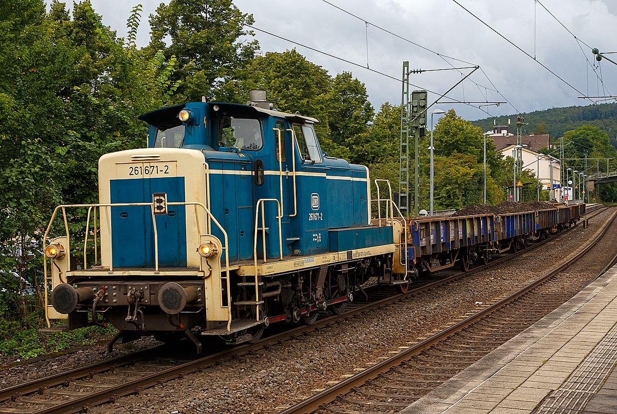 Kleine Lok ganz groß.....
Die 261 671-2 (eigentlich laut NVR-Nummer 98 80 3361 671-1 D-AVOLL) der Aggerbahn (Andreas Voll e.K., Wiehl) fährt am 27.08.2021, mit einem Altschotter bzw. Aushub beladen Flachwagen-Zug (Niederbordwagen für Schotter und Sand der Gattung Klmos 702), durch den Bf Kirchen (Sieg) nach Betzdorf (Sieg).

Die V60 wurde 1959 von MaK unter der Fabriknummer 600260 als DB V 60 671 gebaut, 1968 erfolgte die Umzeichnung in DB 261 671-2, 1984 erfolgte schon die Ausmusterung bei der DB. Die Lok wurde nicht remotorisiert und hat so noch einen originalen gedrosselten Maybach 4-Takt-12-Zylindermotors mit 48 Liter Hubraum vom Typ GTO6A mit einer Leistung von 478 kW (650 PS) bei 1.400 U/min (ungedrosselt 588 kW bzw. 800 PS).

Die dieselhydraulische Lokomotive ist für den leichten und mittleren Rangierdienst sowie den Übergabezugdienst und bei Doppeltraktion auch für den schweren Rangierdienst vorgesehen. Sie hat ein hydraulisches Getriebe und Stangenantrieb. Bei der Konstruktion wurde Wert auf gute Zugänglichkeit und leichte Tauschbarkeit aller dem Verschleiß ausgesetzten Teile gelegt. Alle Großteile wie Motor, Getriebe, Kühlanlage, Luftpresser und elektrische Hilfsmaschinen können jeweils für sich allein ein- und ausgebaut werden.

In den 50er Jahren schlossen sich 8 Firmen in der Arbeitsgemeinschaft  Agm V 60  mit dem DB-Zentralamt München zusammen, es wurden insgesamt 942 Loks gebaut. Dabei gab es zwei unterschiedlich schweren Ausführungen: 623 Loks mit 48 t Dienstgewicht (BR 260/360) und als schwerere Variante 319 Loks mit verstärkten Rahmen- und Stirnwandblechen mit 54 t Dienstgewicht (BR 261/361), diese Lok ist eine der schweren Ausführung.

Bezeichnet wurden die Loks anfangs alle als V60, wobei nicht auf eine Unterscheidung zwischen leichter und schwerer Ausführung geachtet wurde. Mit Einführung des EDV-Nummernschemas bei der DB im Jahr 1968 wurden die leichten Loks als BR 260 eingereiht, die schwere Ausführung erhielt die BR 261.

Die V 60 ist eine Starrrahmenlok, Achsanordnung C, mit seitenverschieblicher Mittelachse, wobei die Achsen mittels Kuppelstangen von einer Blindwelle angetrieben werden.

Diese Lok hat einen gedrosselten Maybach 4-Takt-12-Zylindermotors mit 48 Liter Hubraum vom Typ GTO6A mit einer Leistung von 478 kW (650 PS) bei 1.400 U/min (ungedrosselt 588 kW bzw. 800 PS). Die Leistung des Dieselmotors wird über eine Schwingmetallkupplung und eine Gelenkwelle auf das hydrodynamische Voith-Getriebe L27zuB übertragen. Das Voith-Getriebe ist mit einem mechanischen Stufen- und Wendegetriebe zu einem Block zusammengeflanscht. Die Kraftübertragung erfolgt über eine zwischen dem 2. und 3. Radsatz liegenden Blindwelle, Blindwellenkurbeln an den beiden Blindwellenenden und Kuppelstangen auf die Räder der Lok.

Technische Daten:
Achsanordnung: C
Länge über Puffer: 10.450 mm
Gesamtachsabstand: 4.400 mm
Raddurchmesser: 1.250 mm (neu) / 1.180 mm (abgenutzt)
Höchstgeschwindigkeit im Streckengang: 60 km/h
Höchstgeschwindigkeit im Rangiergang: 30 km/h
Nennleistung: gedrosselt auf 478 kW (650 PS) bei 1.400 U/min 
Anfahrzugkraft: 117,6 kN
Gewicht: 54,0 t
Kraftübertragung: hydraulisch
Antriebsart: Blindwelle-Stangen
Kleinster befahrbarer Krümmungsradius: 100m

Übersicht der Baureihen-Bezeichnung (V60):
BR V 60 ursprüngliche Bezeichnung ab Ablieferung bis 1.1.68

BR 260 leichte Ausführung bis Okt. 1987
BR 261 schwere Ausführung bis Okt. 1987

BR 360 leichte Ausführung
BR 361 schwere Ausführung

BR 362 modernisierte leichte Ausführung mit Funk und neuen CAT 3412E DI-TTA Motor
BR 363 modernisierte schwere Ausführung mit Funk und neuen CAT 3412E DI-TTA Motor

BR 364 leichte Ausführung mit Funkfernsteuerung
BR 365 schwere Ausführung mit Funkfernsteuerung