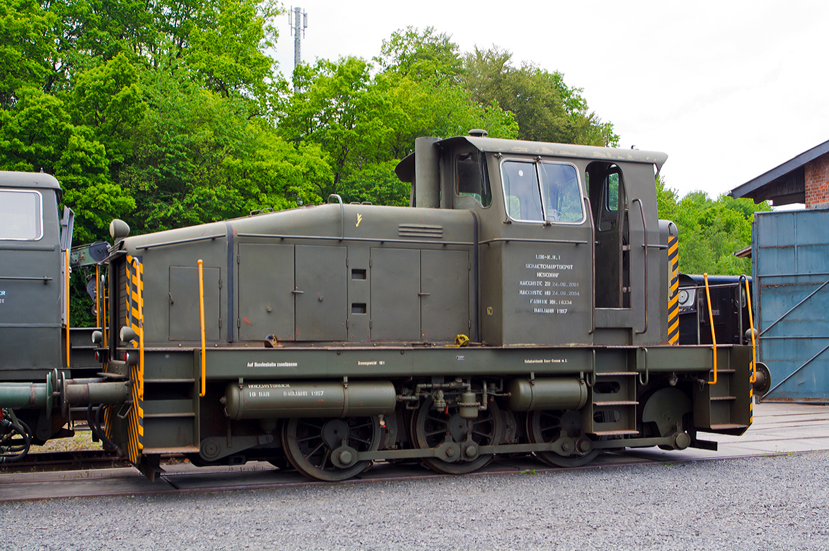 
Krauss-Maffei 18334 eine Krauss-Maffei ML 440 C Diesellokomotive ehemals der Bundeswehr, am 18.05.2014 ausgestellt beim Erlebnisbahnhof Westerwald der Westerwälder Eisenbahnfreunde 44 508 e. V. hier war Museumstag. Die Lok ist Eigentum der Wehrtechnischen Studiensammlung (WTS) in Koblenz und eine Leihgabe an die Eisenbahnfreunde. In der Lokstation Westerburg findet man eine einzigartige Spezialsammlung von Schienenfahrzeugen der Bundeswehr.

Die Krauss-Maffei Lokomotive ML 440 C entstammt der Ahnenreihe der bekannten Wehrmachtslokomotive WR 360 C 14, sozusagen als bayerische Version der V 36. Obwohl Krauss-Maffei nie WR-Diesellokomotiven gebaut hatte. KM war es gelungen, über die MaK Kiel an komplette Zeichnungssätze der Wehrmachtslokomotiven zu kommen, die als basierende Konstruktionsunterlagen unverkennbare Einflüsse auf die Entwicklung der ML 440 C hatten.

War bei der Bauform 1951 mit Endführerstand die Verwandtschaft zur V 36 optisch noch gut erkennbar, so änderte sich das äußere mit Einführung der Regelbauart 1954 (ab der 10. Lok) merklich, unterschied sich von ihrer Vorgängerin durch einen erhöhten, halbmittig angeordneten Führerstand, sowie einem stark angeschrägten Lokomotivkasten zur Verbesserung der Sicht auf die Strecke

Die ML 440 C ist eine dieselhydraulische, dreiachsige Steifrahmen-Lokomotive mit Endführerhaus. Die Kraftanlage besteht aus dem MAN-Dieselmotor W8V 17,5A mit Aufladung, der über eine elastische Kupplung das Flüssigkeitsgetriebe Voith L 37V antreibt. Diesem Getriebe ist ein Kegelrad - Wendegetriebe nachgeschaltet, dem das Stufengetriebe folgt. Von dessen Stufenzahnrädern aus erfolgt die Kraftübertragung mittels Stirnradvorgelege auf die Blindwelle, die ihrerseits über Treib- und Kuppelstangen die Achsen antreibt.
Die Lokomotive ist mit einer Druckluftbremse für Lok und Zug, Bauart Knorr, ausgerüstet. Zur Festsetzung der Maschine im Stillstand ist eine Spindelbremse vorhanden. Zur Ausrüstung gehören neben der Sicherheitsfahrschaltung auch eine Druckluftpfeife und ein Läutewerk.
Die elektrische Anlage für das Anlassen des Motors, die Beleuchtung und Zusatzausrüstungen ist für eine Spannung von 24 Volt ausgelegt. Die Lokomotive hat ein Dienstgewicht von etwa 42 Tonnen und erreicht auf gerader horizontaler Strecke im Verschiebedienst eine Maximalgeschwindigkeit von 28 km/h sowie im Streckendienst von 55 km/h. Bei der Bundeswehr erhielt dieser Loktyp die Versorgungsnummer 2210-12-120-4951.

.

Am 12. April 1957 wurde das Fahrzeug mit der Fabriknummer 18334 an den Gerätepark Hesedorf, später als Material - übernahmegruppe Nord I bezeichnet, ausgeliefert.  Der Preis betrug 235.100.- DM. Damit stand sie als fünfte bundeswehreigene Lokomotive, gekauft durch das Amt für Wehrtechnik und Beschaffung, der Truppe zur Verfügung. 

Mit Erreichen der Fristgrenzen im Jahre 2004 wurde jedoch die aktive Einsatzzeit der Lokomotive durch Abstellung beendet. Das Schicksal der Verschrottung sollte der alten Dame jedoch erspart bleiben. Die Wehrtechnische Studiensammlung (WTS) des BWB konnte dazu bewegt werden, sich für die Erhaltung dieses Zeitzeugen der ersten Stunden des Eisenbahnwesens in der Bundeswehr einzusetzen.


TECHNISCHE DATEN:
Achsformel:  C
Spurweite:  1.435 mm (Normalspur)
Länge über Puffer:  8.700 mm
Höhe:  4.190 mm
Breite:  3.100 mm
Fester Radstand:  3.000 mm
Kleinster bef. Halbmesser:  50 m
Dienstgewicht:  48 t
Radsatzfahrmasse:  16 t
Höchstgeschwindigkeit:  28 km/h im Rangiergang / 55 km/h im Streckengang
Installierte Leistung:  440 PS bei 1.100/min
Treibraddurchmesser:  1.006/mm
Motorentyp:  MAN W 8 V 17,5/22 A
Motorbauart:  8 Zylinder-Viertakt-Reihenmotor mit Abgasturbolader
Leistungsübertragung:  hydraulisch (Voith-Turbo-Getriebe L 37 v)
Anfahrzugkraft  16000 kg / 156,9 kN
Tankinhalt:  1.300 l
Lokbremse:  Knorr Druckluftbremse