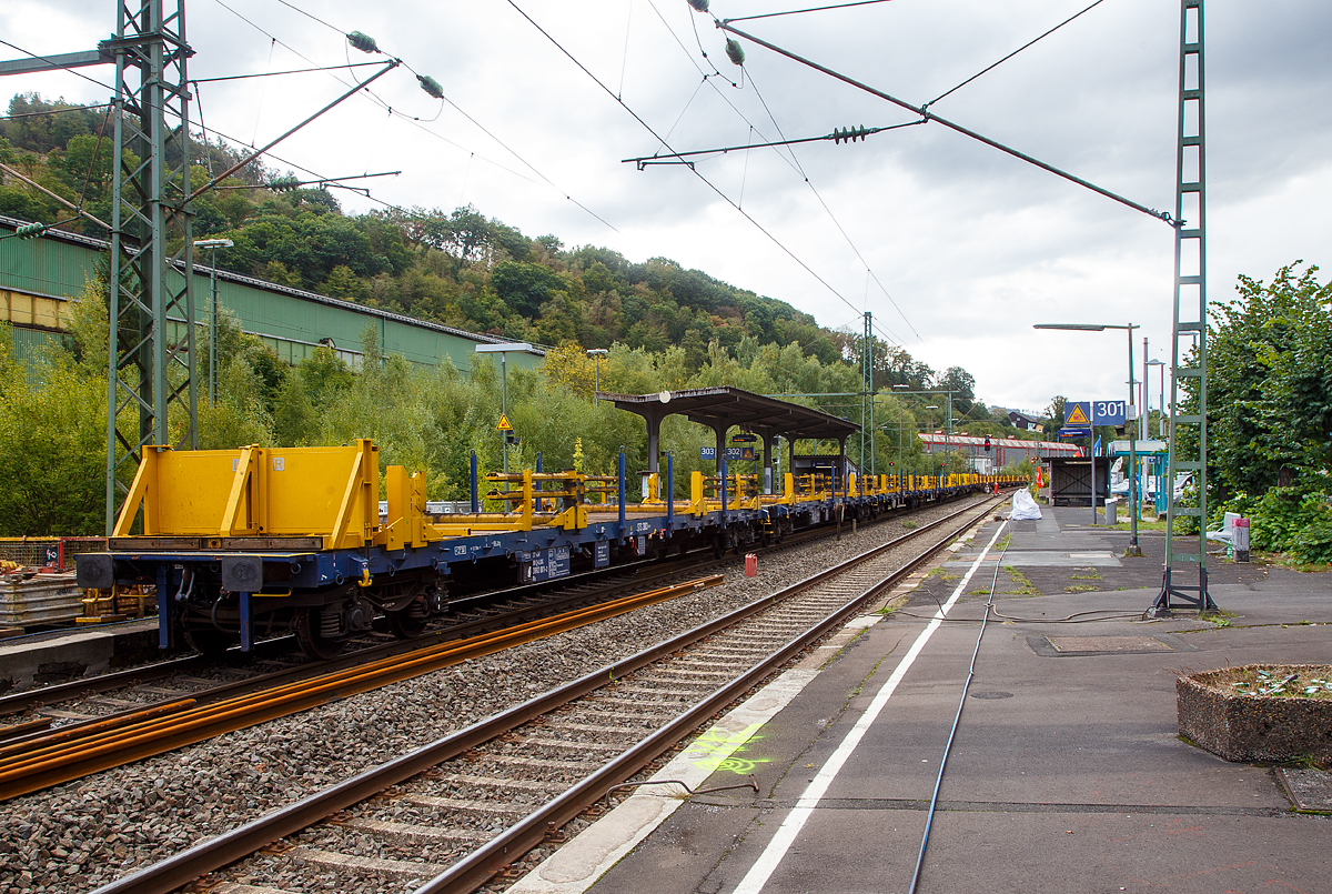 Langschienentransporteinheit STS 3003 (auf 4-achsigen Drehgestell-Flachwagen der Gattung Rs) der Vossloh Rail Service GmbH am 17.09.2022 im Bahnhof Niederschelden (geografisch eigentlich Niederschelderhütte).

TECHNISCHE DATEN je Wagen:
Anzahl der Wagen der Einheit: 6
Spurweite: 1.435 mm
Anzahl der Achsen: 4
Länge über Puffer: 21.700 mm
Drehzapfenabstand: 16.660 mm
Achsabstand im Drehgestell: 1.800 mm
Durchschnittliches Eigengewicht: 6 x 24,4 t/Wg. = 146,4t/Einheit
Breite (zwischen den Rungen): 2.640 mm 
Höhe Fahrzeugboden über SO: 1.230 mm
Höchstgeschwindigkeit: 100 km/h
Kleinster befahrbarer Gleisbogen: unbeladen 75 m, beladen 150 m
Bremse: KE – GP (LL)
Bremssohle: IB 116
Handbremse: nein
Fahrzeugumgrenzungslinie: Lichtraumprofil G1