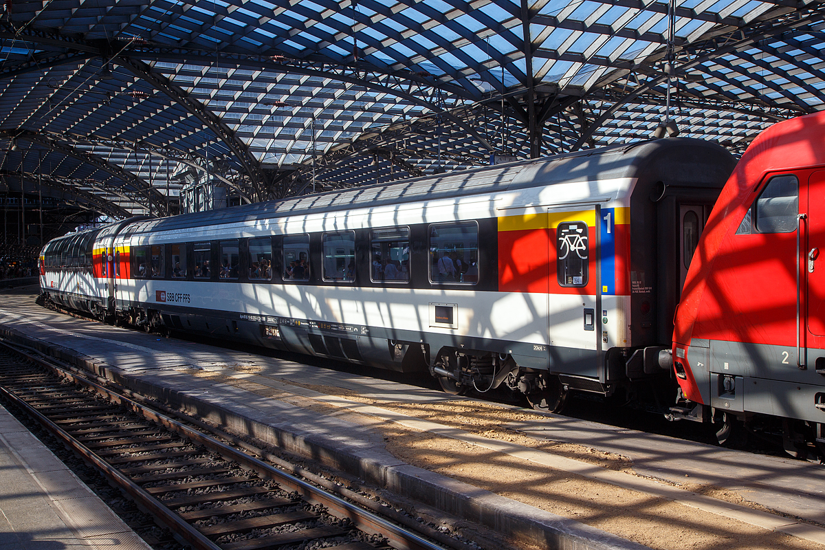 Licht und Schatten unter der bzw. durch Bahnsteigüberdachung vom Hbf Köln....
SBB 1.Klasse Reisezugwagen (EC-Wagen) Apm 61 85 10-90 255-3 CH-SBB am 12.08.2022 im Hbf Köln eingereiht in einen EC.

Die EuroCity-Wagen (Apm EC und Bpm EC) der SBB sind zwar nach ähnlichen Prinzipien aufgebaut worden, werden aber in der Schweiz nicht als Einheitswagen bezeichnet. Konstruktiv zur gleichen Gruppe gehören die Bt IC, die mit den EW IV eingesetzt werden und lediglich eine Einspannungsausrüstung (für 1000 V, 16,7 Hz) aufweisen. 1989–1995 stellten die SBB eine weitere Großraumwagen Serie für den EuroCity-Verkehr in den Dienst, die auf den 1980 abgelieferten Bpm RIC und dem EW IV aufbaute. Für beide Wagenklassen wurde der gleiche Wagenkasten mit zehn Fenstern zwischen den Schwenkschiebetüren an den Wagenenden benutzt. Das Dach war von der gleichen Bauart wie beim französischen Corailwagen, die Längssicken waren aber schon bei den Einheitswagen I bis IV vorhanden. Die Schürzen wurden tiefer gezogen als beim EW IV, so wie es für den EW V vorgesehen war. In den Abmessungen entsprechen die Wagen dem UIC-Z1-Standard. Die Farbgebung in zwei Grautönen mit hellem Streifen dazwischen wurde zuvor bereits für die zu zweiklassigen EuroCity-Zügen umgebauten TEE-Züge (RABe) angewendet. Der helle Streifen des Eurofima-Anstrichschemas wurde beibehalten. Der Bereich über dem weißen Begleitstreifen war nun in Umbragrau gehalten, darunter im helleren Verkehrsgrau A (RAL 7042). Die 60 Sitzplätze der ersten und 78 der zweiten Klasse sind durchgehend in Vis-à-vis-Anordnung gehalten. Diese Wagen sind voll RIC-fähig und für eine Höchstgeschwindigkeit von 200 km/h zugelassen. Insgesamt wurden 70 Apm und 155 Bpm geliefert.

TECHNISCHE DATEN:
Spurweite: 1.435 mm
Anzahl der Achsen: 4 in 2 Drehgestellen
Länge über Puffer: 26.400 mm
Drehzapfenabstand: 19.000 mm
Eigengewicht: 45 t
Höchstgeschwindigkeit: 200 km/h
Sitzplätze: 60 (in der 1. Klasse)
Toiletten: 1
Bremse: O-PR-Mg
