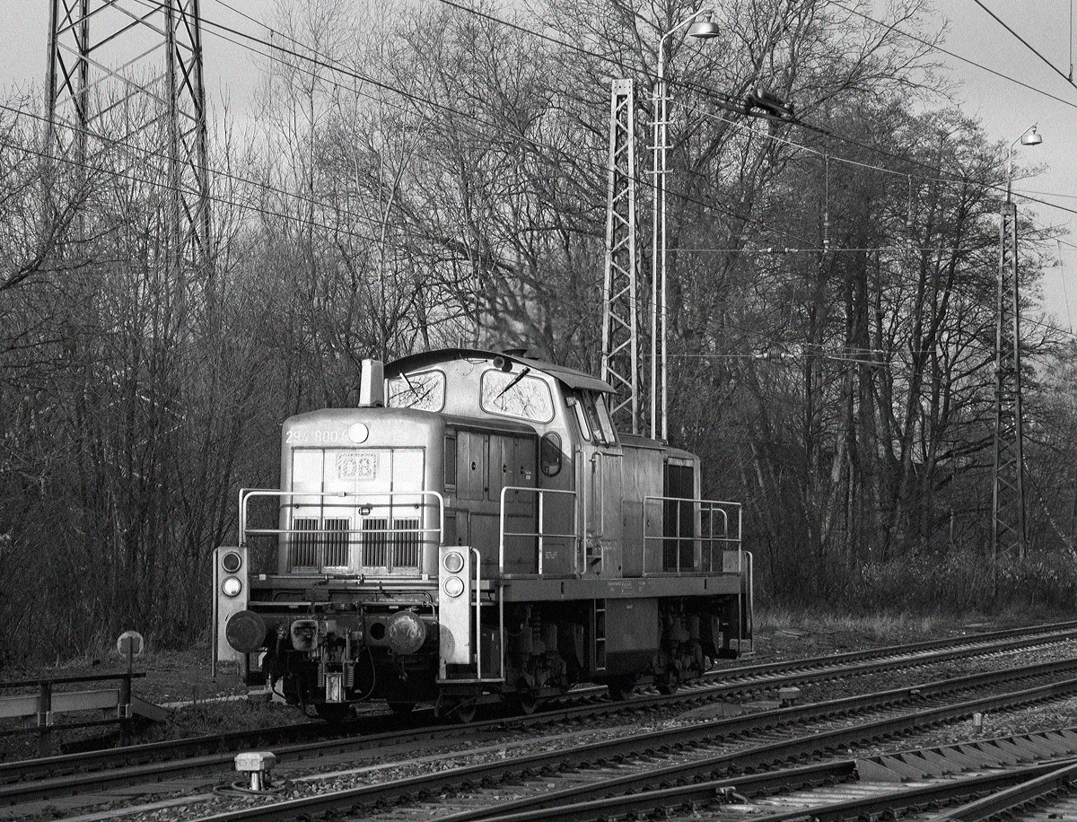 
Mal eine etwas andere Bildbearbeitung...
Die remotorisierte V90 der DB Schenker Rail Deutschland AG 294 800-8 (98 80 3294 800-8 D-DB), ex DB 294 300-9, ex DB 290 300-3, rangiert am 05.12.2015 beim Kreuztal. 

Die Lok wurde 1971 bei Jung, Jungenthal bei Kirchen a.d. Sieg unter der Fabriknummer 14146 als 290 300-3 für die DB gebaut, 1997 erfolgte der Umbau auf Funkfernsteuerung und Umzeichnung in 294 300-9. 

Die Remotorisierung mit einem MTU-Motor 8V 4000 R41, Einbau  einer neuen Lüfteranlage, einem neuen Luftpresser und Ausrüstung mit dem Umlaufgeländer erfolgten 2002 bei der DB Fahrzeuginstandhaltung GmbH im Werk Cottbus. Daraufhin erfolgte die Umzeichnung in 294 800-8.