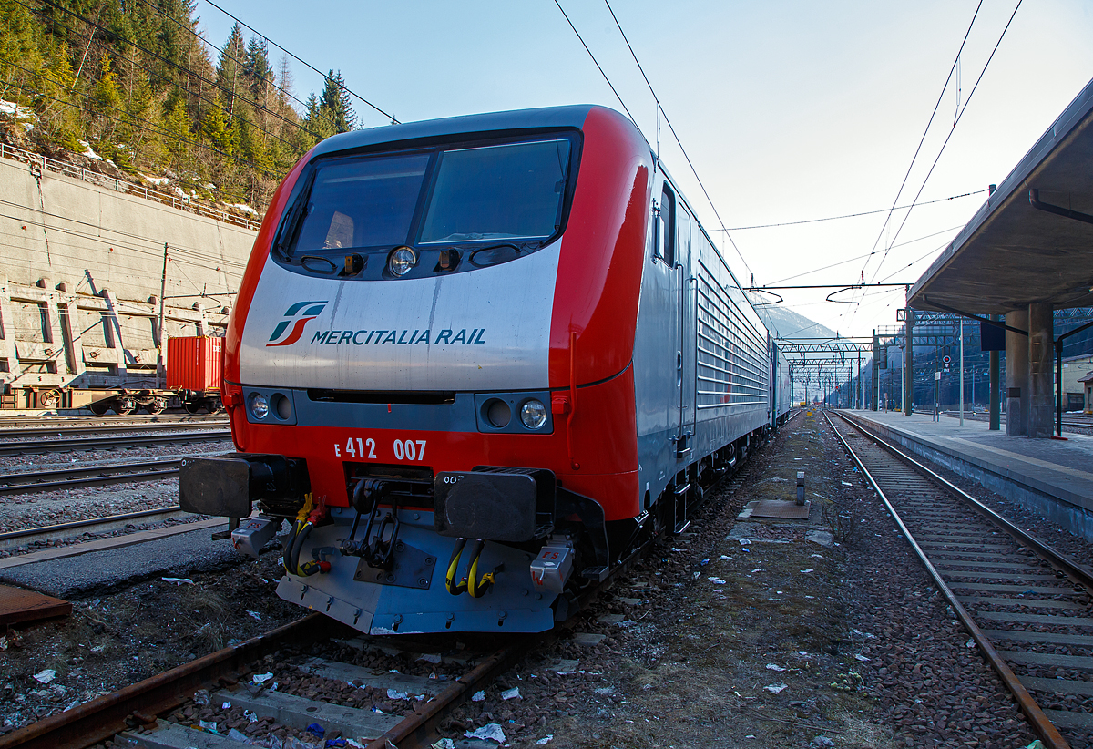 Mit neuer Mercitalia Rail Lackierung ist die Brennerlok E.412.007 (91 83 2412 007- I-TI) am 27.03.2022 beim Bahnhof Brenner / Brennero abgestellt.

Die Lok wurden 1997 vom damaligen Hersteller ABB Tecnomasio in Vado Ligure (Italien), später Bombardier, heute Alstom, unter der Fabriknummer 7422 gebaut und an die Trenitalia S.p.A. geliefert. 

Die Brennerloks vom Typ Adtranz 112E sind ähnlich denen später von Bombardier in Polen (2001/2) gebauten 8 Loks für die polnische PKP - Polskie Koleje Państwowe vorgesehen EU43 vom Typ Bombardier 112E. Der Verkauf scheitere aus finanziellen Gründen seitens der PKP. Die 8 polnischen Loks sind danach an die italienische Gesellschaft RTC (Rail Traction Company) verkauft worden, die polnische Bezeichnung EU43 wurde später an Lokomotiven der TRAXX-Variante MS2 vergeben.
