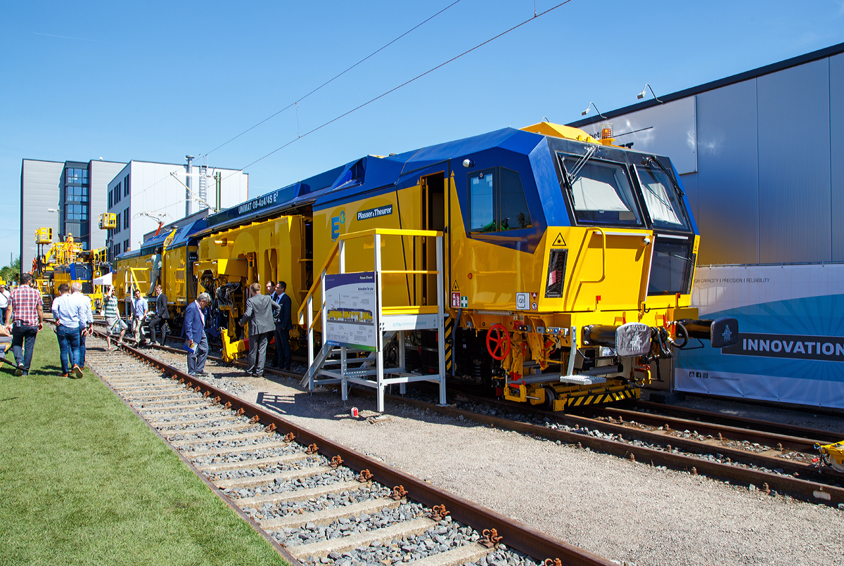 
Neues Maschinendesign und neue E³-Antriebstechnologie von Plasser & Theurer....
Die Plasser & Theurer  UNIMAT 09-4x4/4S E3 ATW (A-PLA 99 81 9124 004-8),  eine Universal-Weichenstopfmaschine mit Hybrid-Antriebstechnik, der Franz Plasser Vermietung von Bahnbaumaschinen GmbH präsentiert auf der iaf 2017 in Münster (am 01.06.2017).
Die Maschine wurde 2017 von Plasser & Theurer  in Linz unter der Fabriknummer 6557/58 gebaut.
E³ steht für Economic, Ecologic und Ergonomic

Die Idee kommt eigentlich von der Krebs Gleisbau AG, die bereits 2016 eine Universal-Weichenstopfmaschine für die Instandhaltung Schweizer Gleise erhalten hat, diese War noch im alten Maschinendesign.

Neben einem geringeren Schadstoffausstoß und der Einsparung von fossilen Treibstoffen wird mit dem Hybrid-Antriebskonzept E³ der Maschinenlärm reduziert. Zusätzlich sind im Bereich aller Arbeitsaggregate Maßnahmen zur Schallreduzierung eingebaut. 
Die Fahrantriebe sind elektrisch im Dieselbetrieb diesel-elektrisch. Im Arbeitsmodus werden alle Drehbewegungen elektrisch, Linearbewegungen hydraulisch. Zudem wir im Dieselbetrieb überschüssige elektrische Energie ins Netz zurück gespeist. 

Zwei Betriebsmodi für den Überstell- und Arbeitsbetrieb steuern, wie die Energiequelle mit dem Antriebssystem zusammenwirkt
Elektrischer Fahrmodus und Arbeitsmodus:
Der Strom aus der Oberleitung wirkt via Transformator und Stromrichter auf Versorgung und Antrieb der Maschine. Die hydraulischen Komponenten, wie das Hebe-Richtaggregat oder die Beistellzylinder des Stopfaggregates, versorgt eine elektrisch angetriebene Hydraulik-Einheit.

Diesel-elektrisch angetriebener Fahrmodus und Arbeitsmodus:
Der 600-kW-Dieselmotor liefert die Energie für die elektrische Versorgung der Antriebskomponenten über den Trafo und Stromrichter. Er wirkt dabei als Generator. Im Arbeitsbetrieb funktionieren die Aggregate gleichermaßen wie im elektrischen Modus.

Wichtigster Vorteil ist die Reduktion von der CO2-Emission und von Lärm (10 dBA Lärmreduzierung).
Weniger Triebstoffverbrauch, höhere Energieeffizienz im Diesel-elektrischen Betrieb.
Elektrisch fahren und arbeiten reduziert Lärm- und CO₂-Emissionen.

TECHNISCHE DATEN:
Spurweite: 1.435 mm (Normalspur)
Anzahl der Achsen: 8 
Länge über Puffer:  34.140 mm
Achsabstand im Drehgestell: 1.800 mm
Raddurchmesser (neu): 920 mm
Eigengewicht: 142.000 kg
Kleister befahrbarer Gleisbogen: R = 150 m 
Zugelassen für Streckenklasse: C2 und höher
Höchstgeschwindigkeit: 100 km
Wirkungsgrad: bis zu 94 %