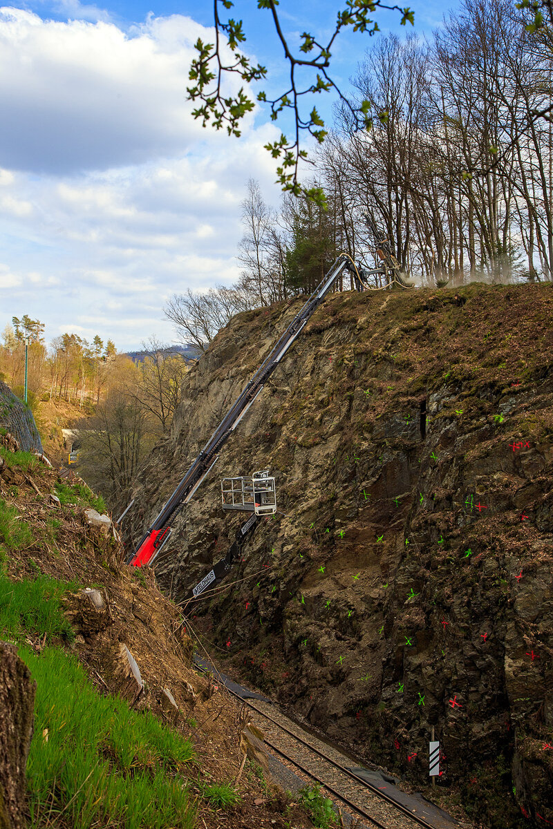 Nun haben die Felssicherungsarbeiten endlich begonnen....
Am 23. Dezember 2022 ca. 18:15 Uhr kam es hier, in Herdorf kurz hinter dem Hp  K�nigsstollen (bei km 88,4 der Hellertalbahn KBS 462), zu einem Felssturz und der HLB Triebwagen VT 507, als RB 96 „Hellertalbahn“ entgleiste, verletzt wurde zum Gl�ck niemand. Nun nach �ber vier Monaten haben endlich die erforderlichen Sicherungsma�nahmen begonnen, hier am 27.04.2023. Zuerst m�ssen viele 4 m lange Anker in den Fels getrieben werden. Die Arbeiten werden von der Firma FELDHAUS Bergbau GmbH & Co. KG aus Schmallenberg (Hochsauerland) ausgef�hrt. 
