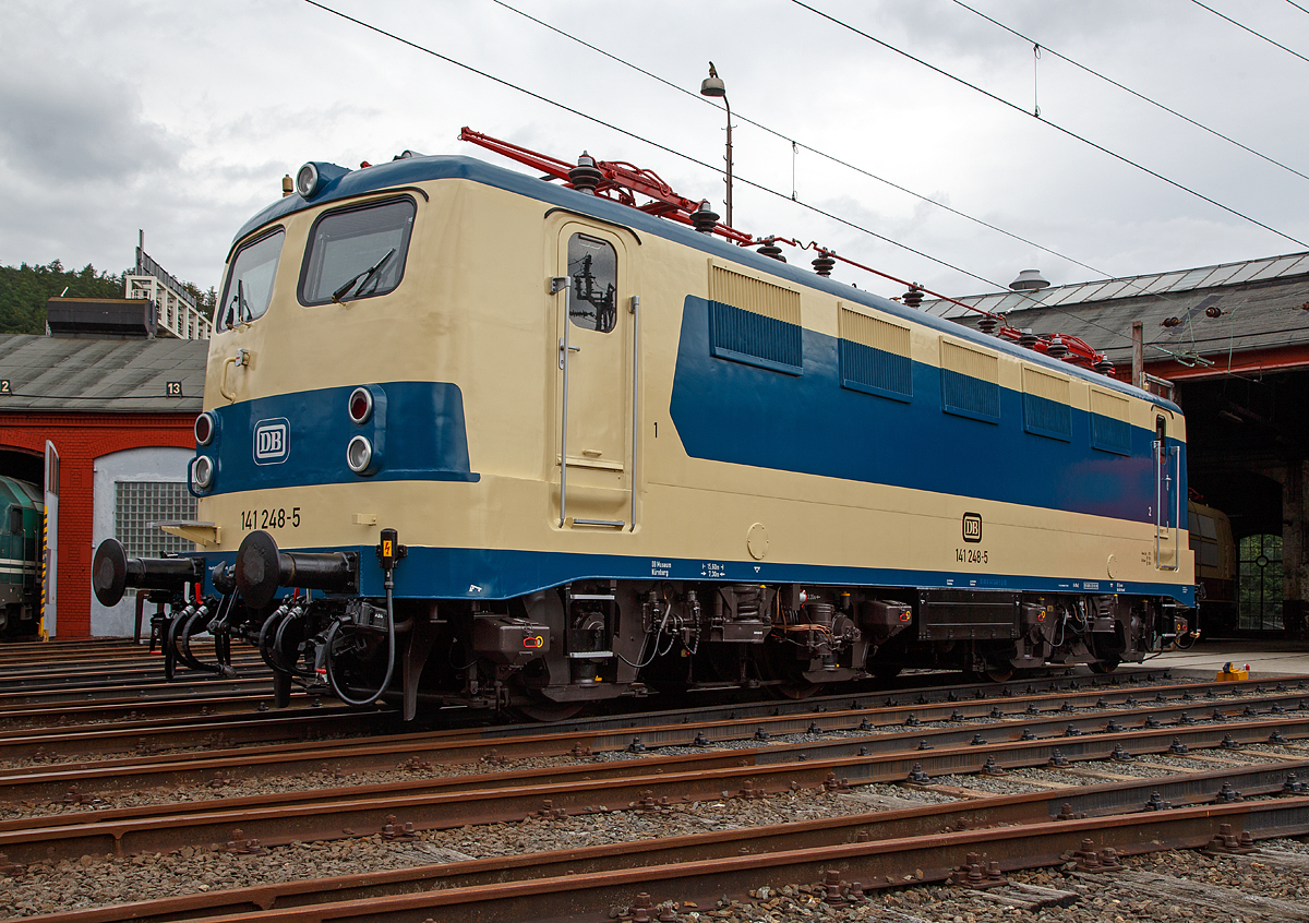 
Nun wieder in der blau/beige Sonderlackierung des  Karlsruher Zuges , diesen trug sie von 1977 bis 2000...........
Die 141 248-5, ex DB E 41 248, wird am 20.08.2016 beim Lokschuppenfest vom Südwestfälischen Eisenbahnmuseums in Siegen vor dem Ringlokschuppen präsentiert. Nach nun nach 16 Jahren in „Verkehrsrot“ wieder  in der Sonderlackierung des  Karlsruher Zuges , so war sie früher auch sehr oft auf der Ruhr-Sieg und der Dill-Strecke zu sehen. Sie war auch die einzige in dieser Versuchslackierung zum Karlsruher Wendezug (grün-beige), diesen trug sie 1977 bis 2000.
 
Die Lok wurde 1963 von Henschel unter der Fabriknummer 30451 gebaut, der elektr. Teil von Brown, Boveri & Cie AG (BBC). Im Jahr 2003 wurde sie z-gestellt, heute ist sie Eigentum vom DB-Museum Nürnberg und eine Leihgabe an das Südwestfälisches Eisembahnmuseum (Bw Siegen).

Von 1977 bis 1995 war der  Knallfrosch“ dem BW Hagen-Eckesey zugeteilt, im Januar 1977 erhielt sie den asymmetrischen S-Bahn-Versuchslack, der der allgemeinen ozeanblau-beigen Farbgebung ähnelt. Die Lok sollte immer mit der gleichen Seite an einem mit blauen Fensterband umgerüsteten Versuchszug der BD Essen aus umgebauten Silberlingwagen für den S-Bahn-Verkehr am Zug hängen, damit Lok und Wagen farblich harmonierten. Dieser Zug, der sogenannte „Karlsruher Zug“, war der Prototyp für die bis heute zahlreich eingesetzten S-Bahn-Züge, gebildet aus Lokomotiven der Baureihen 111 bzw. 143 und drei bis fünf x-Wagen.