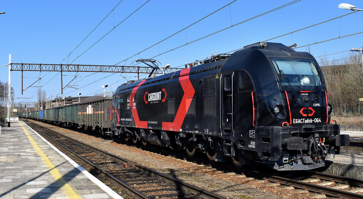 ORLEN KolTrans Sp. z o.o. mit der von Cargounit geleasten neuen Zweikraftlok Dragon2 (mit Dieselmodul)  E6ACTadnb-064 , Name:  KAMIL  (NVR:  91 51 3 160 490-1 PL-ID ) und einem Ganzzug Hochbordwagen für die Fa. QEMETICA Cargo Sp. z o.o.  am 18.03.26 Durchfahrt Bahnhof Kostrzyn nad Odrą (Polen).