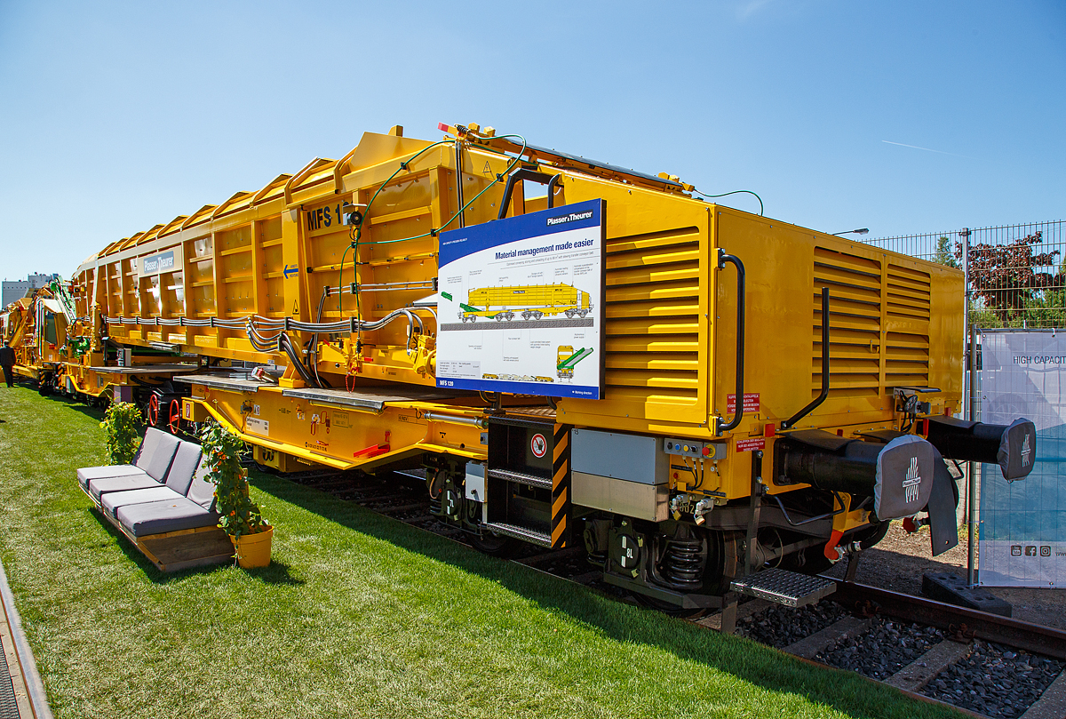 Plasser & Theurer Materialförder- und Siloeinheit MFS 120, Schweres-Nebenfahrzeug-Nr. 99 81 9352 085-0 A-PLA, der Franz Plasser Vermietung von Bahnbaumaschinen GmbH, präsentiert auf der iaf 2017 in Münster (am 01.06.2017).

Die Materialförder- und Siloeinheit MFS 120 wurde 2017 von Plasser & Theurer  in Linz (A) unter der Fabriknummer 6540 gebaut-

Die Materialförder- und Siloeinheit ist zum kontinuierlichen Be- und Entladen. Die MFS 120 sind für optimiertes Fördern, Speichern. Entladen bis 68 m³ mit schwenkbarem Übergabeförderband ausgestattet. Sie kann gleichzeitig beladen und entladen werden. Die Steuerung kann hierbei auch über eine Fernbedienung erfolgen. Das schwenkbare Übergabeförderband ermöglicht den Materialtransport zum nächsten Wagen oder in geschwenkter Stellung neben das Gleis. Als Neuheit besteht die Möglichkeit, das Übergabeförderband in das Drehgestell zu versenken. Beim Abtransport der Wagen kann so auf den bislang notwendigen Schutzwagen verzichtet werden. Die MFS 120 sind kompatibel zu den bisherigen Wagen (z.B. MFS 100).

Materialförder- und Siloeinheiten dienen zum Transport von Schotter, Abraum und Pufferspeicher bei der Bettungsreinigung bzw. Planumsverbesserung. Hauptvorteil ist der kontinuierliche Förder-, Speicher- und Entladevorgang. Eine Zusammenstellung von beliebig vielen MFS-Wagen zu einem Zug mit jeweils gewünschter Speicherkapazität ist möglich. Der Füllvorgang beginnt beim vordersten Wagen (in Arbeitsrichtung), die folgenden Wagen dienen als Förderstraße.

TECHNISCHE DATEN:
Spurweite: 1.435 mm
Achsanzahl : 8 (in 4 Drehgestellen)
Länge über Puffer: 22.900 mm
Gesamtlänge mit ausgefahrenem Förderband: ca. 26 640 mm
Drehzapfenabstände: 6.650 m / 4.800 mm / 6.650 m
Achsabstand in den Drehgestellen: 1.800 mm
Laufraddurchmesser: 920 mm (neu)
Höhe:  4.165 mm (Arbeit) / 3 974 mm (Schleppfahrt)
Breite:  3.183mm
Leergewicht: 65.000 kg
Siloinhalt (theoretisch): 68 m³
Nutzlast:  80,5 t (ab C2) / 98,6 t (ab D 3) / 112,5 t (ab D 4)
Höchstgeschwindigkeit: 100 km/h 
Bremse: KP-GE-A (Max. 147 t)
Handbremse: Ja (einzeln auf 2 Drehgestelle)
Kleister befahrbarer Gleisbogen: R = 150 mm
Diesel-Motorleistung: 129 kW (für Hydraulische Antriebe)
Schwenkbereich des Übergabebandes: ±45°
Förderbandbreiten (Bodenförderband):  1.980 mm
Förderbandbreiten (Übergabeband):  1.900 mm