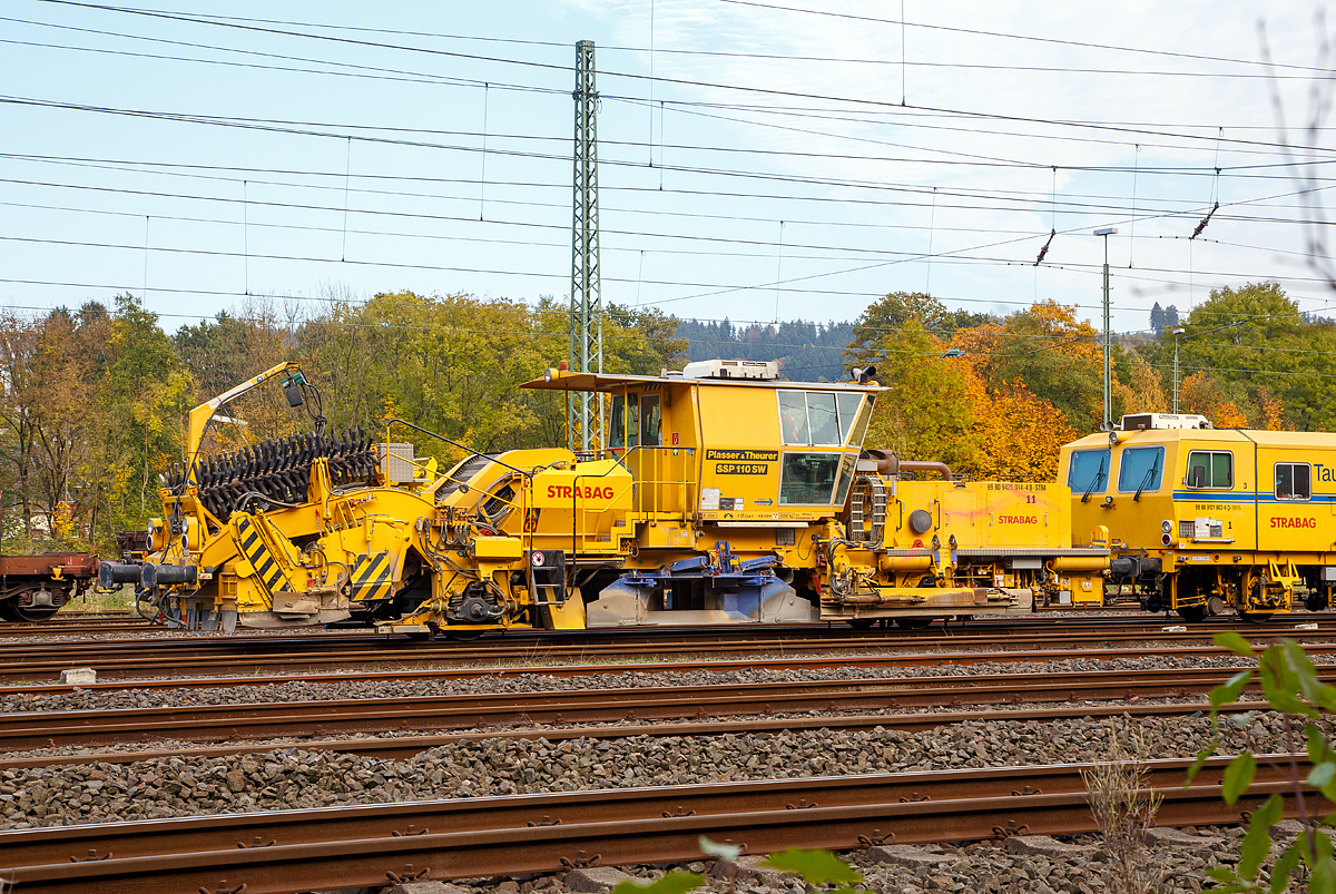 
Plasser & Theurer Schnell-Schotterverteil- und Planiermaschine SSP 110 SW, Schweres Nebenfahrzeug Nr. 99 80 9425 014-4 D-STRA, der STRABAG abgestellt am 23.10.2016 in Betzdorf/Sieg. Dahinter die STRABAG Tauberexxpress eine Stopfexpress CSM 09 – 3X, Schweres Nebenfahrzeug Nr. 99 80 9121 004-2 D-BRS.

Ausrüstung:

- Schottersilo mit 5 m³ Volumen
- hydraulisch verstellbare Schottersilohosen  innen und außen zur Verteilung des Schotters in die Stopfzonen
- Ersatzbesenschwellen für B70 normal, B70 tief und Weichenschwellen
- Kleineisenbürsten
- Querförderband zur Verteilung des überzähligen Schotters nach rechts und links
- höhenverstellbare Bürstenwelle
- Linienleiterabdeckung für Kehrbesen
- Panoramakomfortkabine zur besseren Bedienung


Technische Daten:
Hersteller: Plasser & Theurer
Baujahr: 2011 (Fabriknummer 911)
VDM-Nr.: 99 80 9425 014-4 D-STRA

Motor: wassergekühlter Deutz-Dieselmotor BF 8 M 1015 C, 
aktiver  Rußpartikelfilter
Leistung: 400  kW
max. Geschwindigkeit in Eigenfahrt: 100 km/h
max. Geschwindigkeit in Schleppfahrt: 100 km/h
Eigenfahrtrichtung: beidseitig
Achsanzahl:  2
Sifa / PZB / Zugbahnfunk  (analog /digital):  Ja
Arbeitsgeschwindigkeit: bis 3.000 m/h (Gleis)
Arbeitsweise: kontinuierlich
min. Radius bei Arbeit: 180 m
min. Radius bei Fahrt: 120 m

Fahrzeug: 
Zulassung:  gemäß Richtlinien EBA/DB AG §32
Spurweite: 1.435  mm
Eigengewicht:  43.000 kg
Höhe: 4.255  mm
Breite: 3.000  mm
Länge über Puffer: 17.225 mm
Achsabstand: 8.100 mm
Kraftstoffvorrat (Diesel): 1.040 l
Streckenklasse: D 4 oder höher
