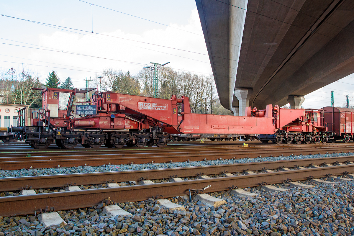 
Schienentiefladewagen (Tragschnabelwagen) mit Sondereinrichtungen mit 12 Rads�tzen der Gattung Uaai 821 der HCS (Heavy Cargo + Service), eingestellt als 86 80 995 2 920-8 D-NCS, abgestellt am 21.11.2015 in Kreuztal.

Bei diesem Fahrzeug handelt es sich um einen zw�lfachsigen Schienentiefladewagen mit Sondereinrichtungen auch Tragschnabelwagen genannt. Diese Bauart erm�glicht auch Transporte von selbsttragenden Ladeg�tern, die ohne Durchladel�ngstr�ger direkt in die Tragschn�bel eingeh�ngt werden. Der Wagen wurde 1970 bei Krupp gebaut und an die Deutsche Bundesbahn geliefert. 

Die HCS (Heavy Cargo + Service) ist eine Tochterfirma der NCS (NUCLEAR CARGO + SERVICE GmbH in Hanau), diese geh�rte bis Dezember 2006 zur DB Schenker und wurde an die franz�sische DAHER S.A. verkauft.


Wagenausr�stung:
- Durchladel�ngstr�ger bzw. eingeh�ngtes Ladegut hydraulisch um +/-400 mm seitenverschiebbar (nur bei Au�enf�hrung)
-  Hubh�he + 400/ - 40 mm 
- Einh�ngebreite f�r Ladeg�ter von 2400 - 3400 mm stufenlos einstellbar
- Tragschn�bel, mit oder ohne Durchladel�ngstr�ger, sind auf Stra�enschwerlastfahrzeuge der DAHER-NCS umsetzbar
    
Technische Daten:
Spurweite: 1.435 mm (Normalspur)
Anzahl der Achsen: 12 in 4 Drehgestellen
Gattungszeichen/Bauartnummer: Uaai 821
L�nge �ber Puffer: 30.124 mm (mit Durchladetr�ger wie hier im Bild, bei eingeh�ngtem Ladegut ist sie ladegutabh�ngig)
L�nge �ber Puffer in Transportstellung ohne Durchladetr�ger: 20.900 mm
Achsabst�nde in den Drehgestellen: 1.500 mm
Laufraddurchmesser: 900 mm
Eigengewicht: 84.550 kg
Eigengewicht der Durchladel�ngstr�ger: 9.380 kg
Kleinster befahrbarer Gleisbogenhalbmesser: 50 m
H�chstgeschwindigkeit (unbeladen): 90 km/h
Bauart der Bremse: KE-GP
Bauart der Handbremse: Spindelhandbremse
H�chstzul�ssiger Knickwinkel (nbeladen): 2� 30'
Lastgrenzen auf Streckenklasse CM4: 84,5 t
Maximale Tagf�higkeit: 190 t (180 t mit Durchladetr�ger