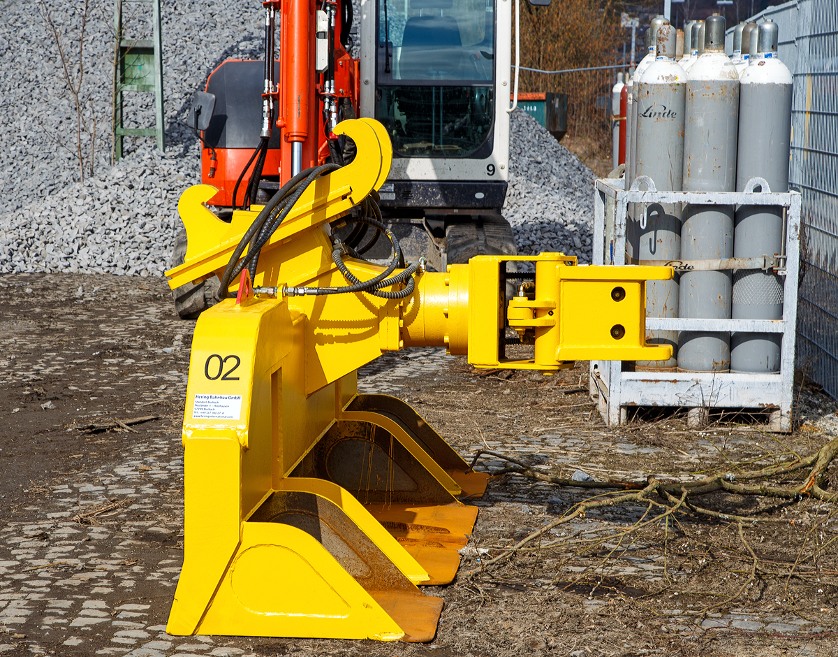 
Schwellenwechselgerät HSW der Hering Bahnbau GmbH, zum Anbau an einen Zweiwege-Bagger, abgestellt am 13.03.2016 beim Bahnhof Westerburg. 

Das Anbaugerät wurde 07/2011 von Richter & Müller Handelsgesellschaft mbH in Dormagen unter der Serien Nr. W8/N/L-005-8 gebaut. 

Das hydraulische Schwellenwechselgerät HSW ist ein Multifunktionsaggregat für den Aus- und Einbau des Gleisschotterbettes sowie für das Wechseln von Holz- und Betonschwellen. Die Aufnahme des Schwellenwechselgerätes sowie die hydraulische Energieversorgung erfolgt vom Zweiwege-Bagger.

Der Aus- und Einbau der Schwellen erfolgt durch eine hydraulische, 360° endlos drehbare Schwellenzange (recht). Die Positionierung und Konstruktion dieser Zange wurde so gewählt, dass ein sicherer und schonender Aus- und Einbau aller gängigen Holz- und Betonschwellen gewährleistet ist. Es ist kein Wechseln der Zange erforderlich, auch bei unterschiedlichen Schwellenarten.

Um eine hohe Effektivität des Schwellenwechselgerätes zu erreichen, wurde das maximale Volumen bei den fest montierten Schaufelsegmenten gewählt.
Die Grabtiefe des Schwellenwechselgerätes HSW ist durch zwei verstellbare Rollen (die dann auf dem Gleis aufliegen) variabel und somit individuell einstellbar.

Technische Daten:
Gewicht:   1.300 kg
Breite:  2.800 mm
Betriebsdruck: 200 bar  
Spurweite:  1435 mm 