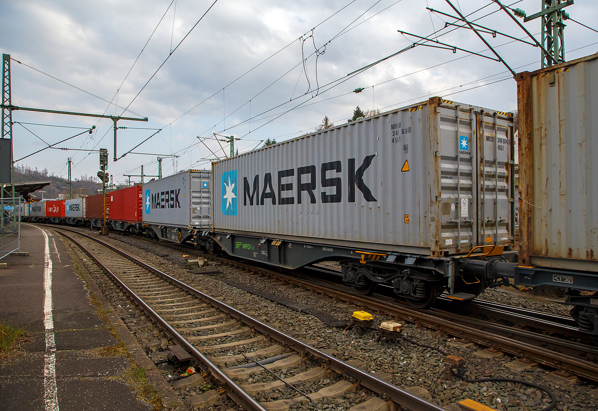 Sechsachsige Gelenk-Drehgestell Containertragwageneinheiten 90´ am 20.03.2022 im Zugverband bei der Zugdurchfahrt im Bf Betzdorf (Sieg), hier im Vordergrund der Wagen 37 80 4963 235-9 D-MFDR, der Gattung Sggmrss M4 (90´), der MFD Rail GmbH (Schweiz).

Diese Gelenkwagen mit sechs Radsätzen sind für den Transport von Großcontainern und Wechselbehältern vorgesehen. Auf den Außenlangträger des Wagens befinden sich für jede vorgesehene Ladeposition feste und klappbare Aufsetzzapfen zum Festlegen der Ladungseinheiten in verschiedenen Kombinationen. 

TECHNISCHE DATEN:
Spurweite: 1.435 mm
Länge über Puffer: 29.590 mm
Drehzapfenabstand: 2 x 12.025 mm
Achsabstand in den Drehgestellen: 1.800 mm
Drehgestelle: 3 x Y25 Ls-K
Laufraddurchmesser: 920 mm (neu)
Ladelänge: 2 x 13.800 mm
Höhe der Ladeebene über S.O.: 1.155 mm
Eigengewicht: 27.500 kg
Max. Zuladung bei Lastgrenze S: 107,5 t (ab Streckenklasse D)
Max. Zuladung bei Lastgrenze SS: 92,5 t (ab Streckenklasse C)
Max. Geschwindigkeit: 100 km/h (Lastgrenze SS und leer 120 km/h)
Kleinster befahrbarer Gleisbogen: R 75 m (Einzelwagen) / R 150 m (Zugverband)
Bremse: 2 x KE-GP-A (Max. 108 t)
Bremssohle: Jurid 816M 320
Feststellbremse: Ja
Intern. Verwendungsfähigkeit: TEN-GE