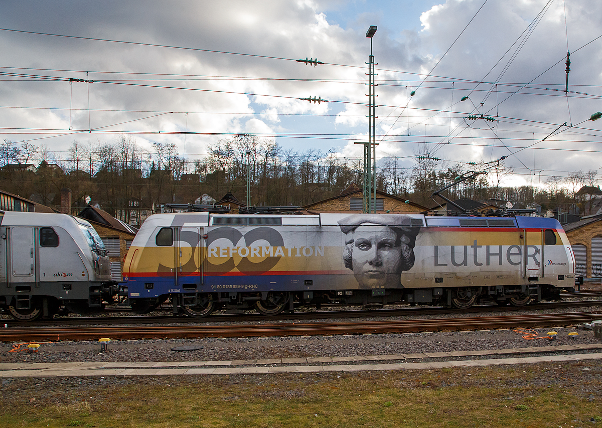 Seitenportrait ...
Die RHC 2057 bzw. RheinCargo 185 589-9  500 Jahre Reformation - Luther   (91 80 6185 589-9 D-RHC), ex HGK 2057 (91 80 6185 589-9 D-HGK), f�hrt am 27.03.2021, mit der kalten AKIEM 187 504-6 und einem mit Dieselkraftstoff bzw. leichtes Heiz�l (laut Gefahrstofftafel 30/1202) beladebenen Kesselwagenzug, durch Betzdorf (Sieg) in Richtung K�ln.

Einen lieben Gru� an die beiden netten und gr��enden Lokf�hrer zur�ck, sorry das ich nicht Vorort gegr��t hatte, ich war mit der Positionierung der Lok zwischen den Masten besch�ftigt und hatte es zu Hause erst gesehen.

Die TRAXX F140 AC2 (BR 185.2) wurde 2008 von Bombardier in Kassel unter der Fabriknummer 34210 gebaut, sie hat die EBA-Nummer EBA 03J15D 040. Zulassungen hat die Lok f�r Deutschland, �sterreich und die Schweiz, sie hat auch vier Stromabnehmer. Eigentlicher Eigent�mer ist die AKIEM SAS, die zum 23.04.2020 das Leasinggesch�ft f�r Schienenfahrzeuge von der Macquarie European Rail Limited (Luxembourg), ehemals CBRail �bernommen hat.

Die Lok war bis 2013 war sie an die HGK (H�fen und G�terverkehr K�ln AG) vermietet, ab 2013 nun an die RheinCargo GmbH & Co. KG (RheinCargo) in Neuss, diese ist ein Gemeinschaftsunternehmen HGK und der Neuss-D�sseldorfer H�fen GmbH & Co. KG (NDH), die jeweils zu jeweils 50 % Eigent�mer sind. Insgesamt geh�ren sieben Binnenh�fen mit einem Gesamtumschlag von 29,7 Mio. Tonnen zum Unternehmen.
