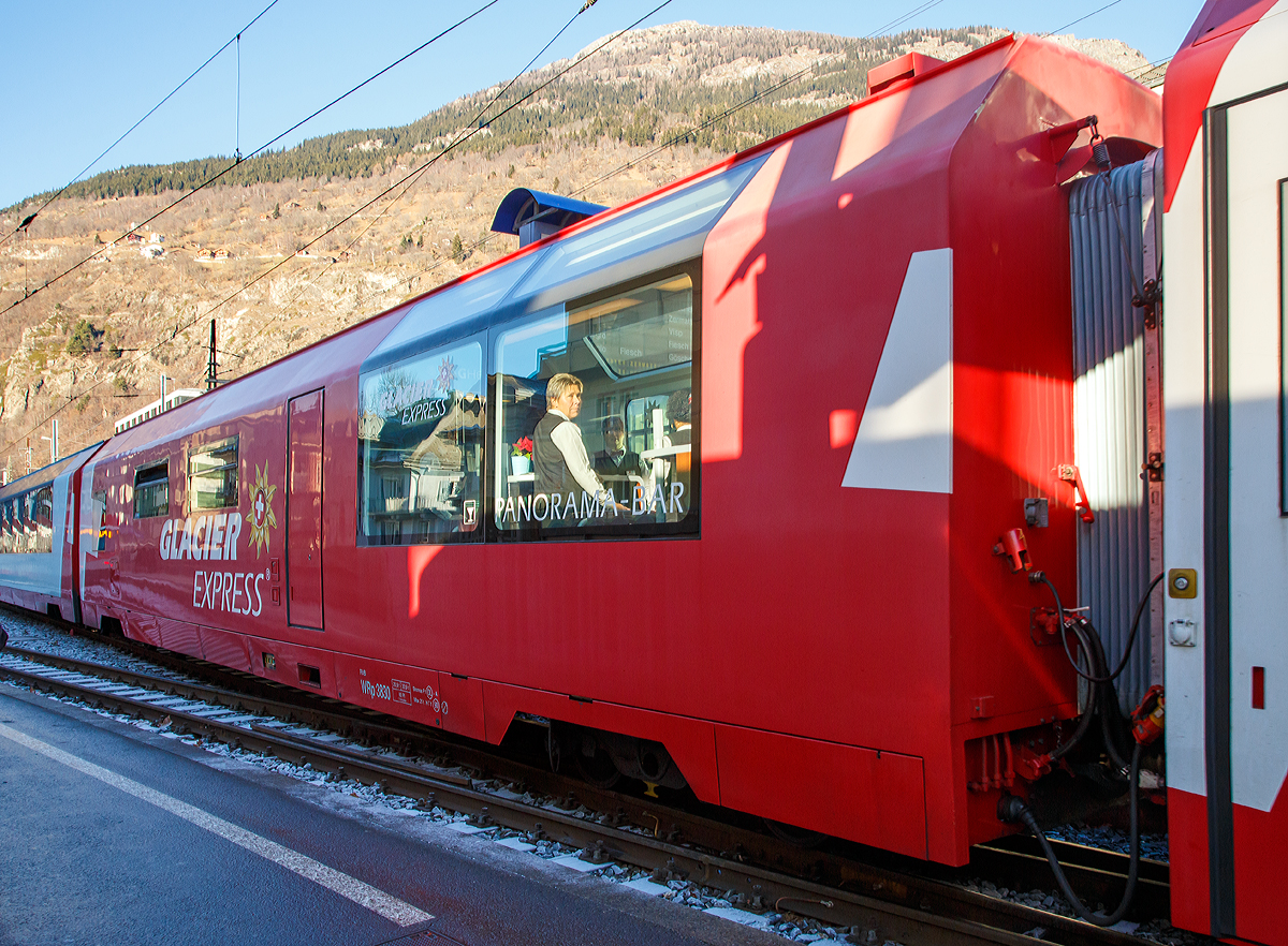 Servicewagen mit Panorama-Bar RhB WRp 3830 „Glacier Express“, hier am 30.12.2015 im Zugverband in Brig.

F�r die Neulancierung des Glacier-Express entschlossen sich RhB und MGB gemeinsam vier ganze Zugskompositionen in Auftrag zu geben. Die Grundkonzeption des Wagens, insbesondere die wichtigsten Masse (L�nge �ber Puffer, Kastenl�nge, Drehzapfenabstand, Fu�bodenh�he und Fensteranordnung) wurden vom Breda-Wagen �bernommen. Die laufen die Wagen auf denselben luftgefederten Stadler-Drehgestellen und der Zug verf�gt nur �ber (bei Bedarf vakuumgesteuerte) Luftdruckbremsen. 

Neu ist, dass in der Mitte ein K�chenwagen mit Panorama-Bar (hier der WRp 3830) l�uft und die G�ste das Essen an den Platz serviert erhalten. Die Wanderung zum Speisewagen (und das Vorhalten der doppelten Anzahl an Sitzpl�tzen) entfallen damit. Jeder Zug ist aus 6 Wagen zusammengesetzt, und zwar in der Reihenfolge Ap-Api-WRp-Bp-Bp-Bp.

Technische Daten:
Spurweite: 1.000 mm 
L�nge �ber Puffer: 18.500 mm
Drehzapfenabstand : 12.830 mm
Kastenl�nge: 17.700 mm
Fahrzeugh�he: 3.695 mm
Fahrzeugbreite: 2.680 mm
Drehgestellachsstand: 1.800 mm
Raddurchmesser, neu: 685 mm
Fu�bodenh�he: 950 mm
Einstiegbreite: 850 mm
L�ngsdruckkraft: 800 kN
Dienstgewicht, tara: 24 t (Servicewagen)
H�chstgeschwindigkeit:   Adh�sion 100 km/h / Zahnstange  35 km/h
Maximale Neigung: Adh�sion 60 ‰ / Zahnstange  125 ‰
Spannung Zugsammelschiene: 320 V (16 2/3 Hz)
Minimaler Kurvenradius: 60 m 