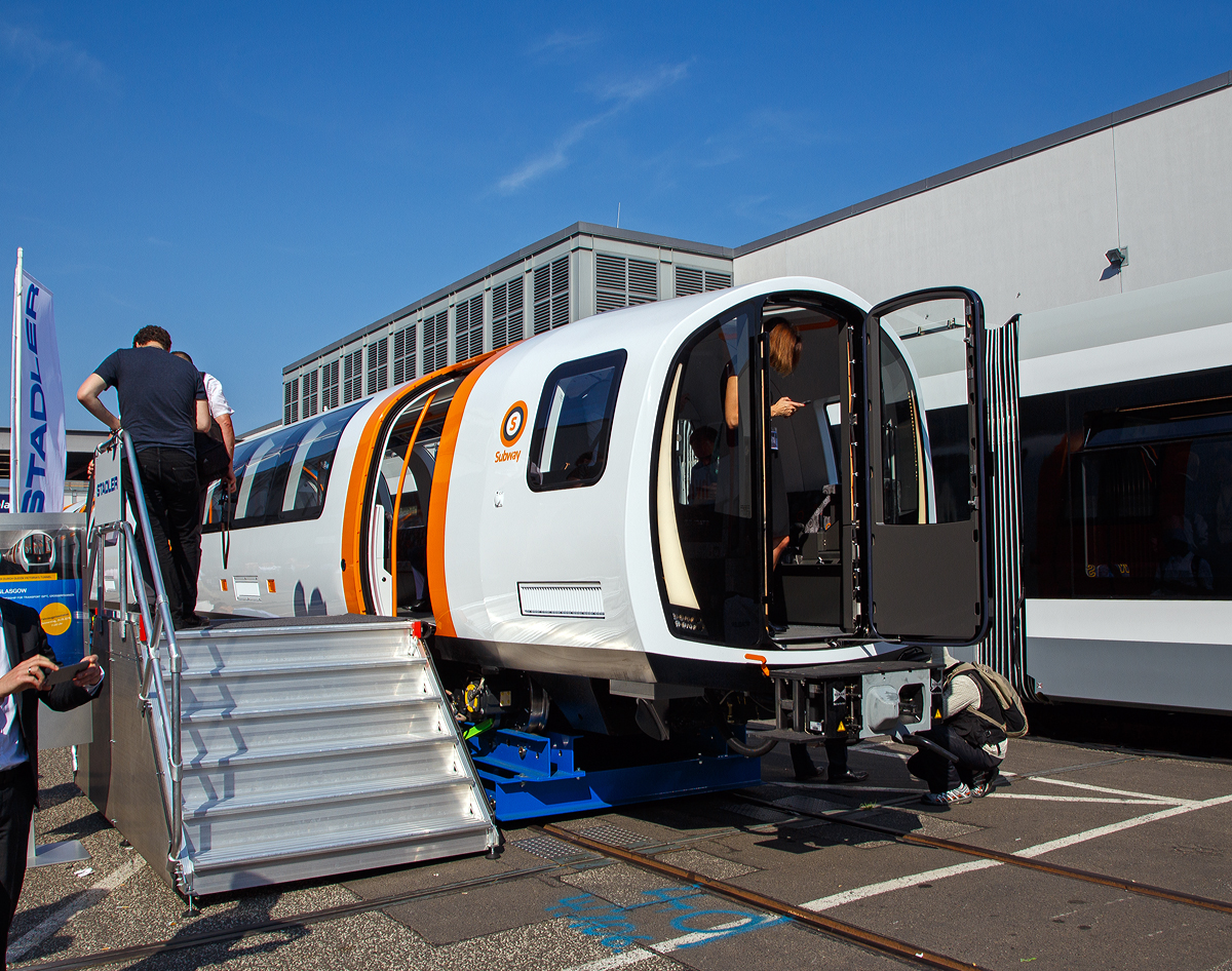 Stadler pr�sentierte auf der InnoTrans 2018 (hier 19.09.2018) in Berlin einen der 17 neuen f�r die Glasgow Subway bestimmten Metroz�ge (METRO GLASGOW EMU). Leider war die ganze Messe so sehr �berlaufen, das mehr Fotos nicht m�glich waren.

Strathclyde Partnership for Transport  (SPT) hat im M�rz 2016 im Rahmen des Modernisierungsprogrammes f�r das U-Bahn-System in Glasgow 17 neue Metroz�ge f�r rund 200 Millionen Pfund bei Stadler bestellt. Glasgow Subway ist das viert�lteste Metrosystem der Welt. Die Er�ffnung der Glasgower U-Bahn war im Dezember 1896. 

Obschon das Tunnelsystem aus viktorianischer Zeit einen sehr engen Durchmesser hat, ist es Stadler gelungen, ein kompaktes Fahrzeug zu bauen, das den Bed�rfnissen anspruchsvoller Fahrg�ste gerecht wird. Der vorhandene Innenraum wird optimal ausgenutzt und bietet auch Platz f�r Rollst�hle. Das Interieur ist offen und freundlich gestaltet. Das neu entwickelte Drehgestell mit Luftfederung tr�gt zu einem komfortableren Fahrerlebnis bei. Die Fahrzeuge sollen vollautomatisch und fahrerlos fahren. Sie haben noch einen tempor�ren F�hrerstand f�r die Migrationsphase und ein Hilfsf�hrerpult f�r Rangierfahrten und Notbetrieb mit den bestehenden Fahrzeugen. 

Die Z�ge verkehren automatisch, die Aufgaben des Fahrers beschr�nken sich darauf, die T�ren zu schlie�en und den Zug in Bewegung zu setzen. Sie tragen zum Teil die urspr�ngliche orangefarbene Lackierung, teilweise sind sie in den Farben der SPT lackiert. Zum hundertj�hrigen Jubil�um der Bahn erhielt der Wagen 122 eine wei�/braune Livree �hnlich der der ersten Kabelbahnwagen[5], ein Beiwagen wirbt in hellblauer Farbgebung f�r die 2014 in der Stadt ausgetragenen Commonwealth Games.

Ein Triebzug besteht aus zwei Halbz�gen mit identischer Antriebsausr�stung. Die Wagenk�sten sind aus Aluminium-Strangpressprofilen gefertigt und laufen auf luftgefederten Motor- und Laufdrehgestellen. Die Fahrzeuge haben durchg�ngig die gleiche Fu�bodenh�he im gesamten Fahrgastraum und besitzen einen gro�z�gigen Mehrzweckbereich. Ein Halbzug besteht aus aus vier Wagenk�sten mit sechs Drehgestellen, die beiden Mittelwagenk�sten mit nur einem Drehgestell sind auf die Endwagen aufgesattelt. F�r den raschen Personenfluss, hat ein Halbzug sechs Einstiegst�ren je Seite. Die Energieversorgung der Fahrzeuge erfolgt �ber eine dritte Schiene mit 600 V DC. Die Fahrzeuge sind f�r eine H�chstgeschwindigkeit von 58 km/h ausgelegt.

TECHNISCHE DATEN, je Halbzug:
Spurweite: 1.220 mm
Speisespannung:  600 V DC (�ber dritte Schiene)
Achsanordnung Bo'Bo'+ 2' + 2'+ Bo'Bo'
Inbetriebsetzung: 2020
L�nge �ber Kupplung: 3.9240 mm
Fahrzeugbreite: 2.340 mm
Fahrzeugh�he: 2.650 mm
Achsabstand im Drehgestell: 1.650 mm
Treib- und Laufraddurchmesser: 540 mm (neu)
Dauerleistung am Rad: 520 kW
Maximale Leistung am Rad: 820 kW
Anfahrzugkraft (bis 23 km/h): 130 kN
Anfahrbeschleunigung brutto: 1,3 m/s�
H�chstgeschwindigkeit: 58 km/h
Bodenh�he: 695 mm
Einstiegsbreite: 1.200 mm
Sitzpl�tze: 104 und 6 Klappsitze
Stehpl�tze bei 6 Pers./m�: 199

Die Glasgow Subway ist die U-Bahn der gr��ten schottischen Stadt Glasgow. Sie wurde 1896 er�ffnet und war damals nach den U-Bahnen in London, Liverpool und Budapest das viert�lteste U-Bahn-System der Welt. Sie besteht lediglich aus einer vollst�ndig im Tunnel verlaufenden Ringstrecke und wurde seit der Er�ffnung nie erweitert. Betrieben wird sie von der Strathclyde Partnership for Transport (SPT), zusammen mit den Vorortlinien der Eisenbahn bildet sie das Schnellbahnnetz Glasgows.

Die 10,5 Kilometer lange Ringstrecke mit 15 Stationen verl�uft vollst�ndig unterirdisch, nur der Betriebshof bei Govan, im S�dwesten, liegt an der Oberfl�che. Sie verbindet die Innenstadt Glasgows mit dem West End und den s�dwestlichen Vororten s�dlich des Flusses Clyde. Die Strecke wird von Z�gen zweier gegenl�ufiger Linien befahren. Sie wird im Linksverkehr betrieben, die Fahrten auf dem �u�eren Ringgleis (outer circle) mit der Kennfarbe Orange erfolgen im Uhrzeigersinn, die auf dem inneren Ringgleis (inner circle) mit der Kennfarbe Grau entgegen dem Uhrzeigersinn. Die Z�ge verkehren werktags zwischen 6:30 Uhr und 23:30 Uhr in Abst�nden von vier bis acht Minuten, sonntags von 10:00 Uhr bis 18:00 Uhr alle acht Minuten.

Die Fahrzeuge laufen auf Schmalspurgleisen mit der ungew�hnlichen Spurweite von 1.219 mm beziehungsweise vier Fu�. Ihren Strom beziehen die Z�ge �ber eine seitliche Stromschiene, deren Spannung bei 600 Volt liegt. Die Tunnel mit einem Durchmesser von lediglich 3,35 Metern befinden sich oft knapp unter der Erdoberfl�che, sie folgen h�ufig den Stra�enverl�ufen. Jene Streckenabschnitte, die die Fl�sse Clyde und Kelvin oder Bahnstrecken unterqueren, liegen tiefer und sind mit Gusseisent�bbings verkleidet. Sie machen etwa ein Drittel der Strecke aus. Die Tunnelw�nde der beiden Fahrtrichtungen liegen rund 0,75 bis 1,8 m voneinander entfernt. Der Streckenverlauf weist Steigungen von bis zu sechs Prozent auf. Tiefste Station ist Buchanan Street, die zw�lf Meter unter der Oberfl�che liegt.

Quellen: Stadler Rail und Wikipedia (�ber die U-Bahn selbst)

