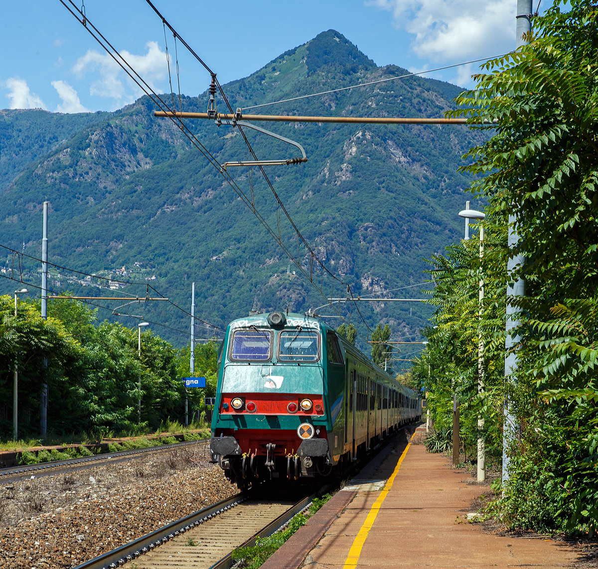 
Steuerwagen voraus fährt ein Trenitalia RE von Domodossola nach Milano Centrale durch den Bahnhof Vogogna (Stazione Ferroviaria di Vogogna Ossola).