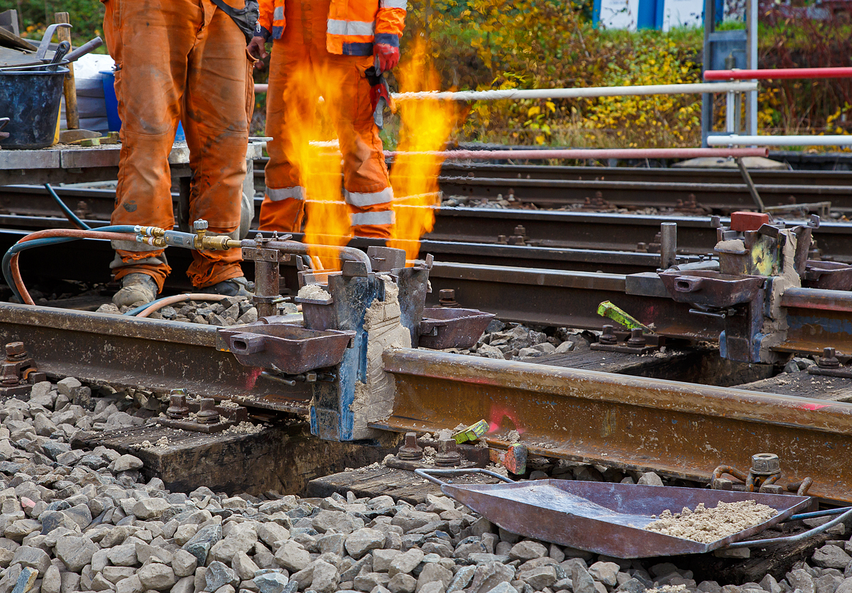 
Thermitschweißen am 31.10.2020 an der Hellertalbahn (KBS 462 / DB-Streckennummer 2651) hier Gleis 1 vom Bahnhof Herdorf.

Bild 2 - Die Gießformen und das Abdichtmedium werden mittels Vorwärmbrenner getrocknet, die Schienenenden werden gleichzeitig vorgewärmt.
