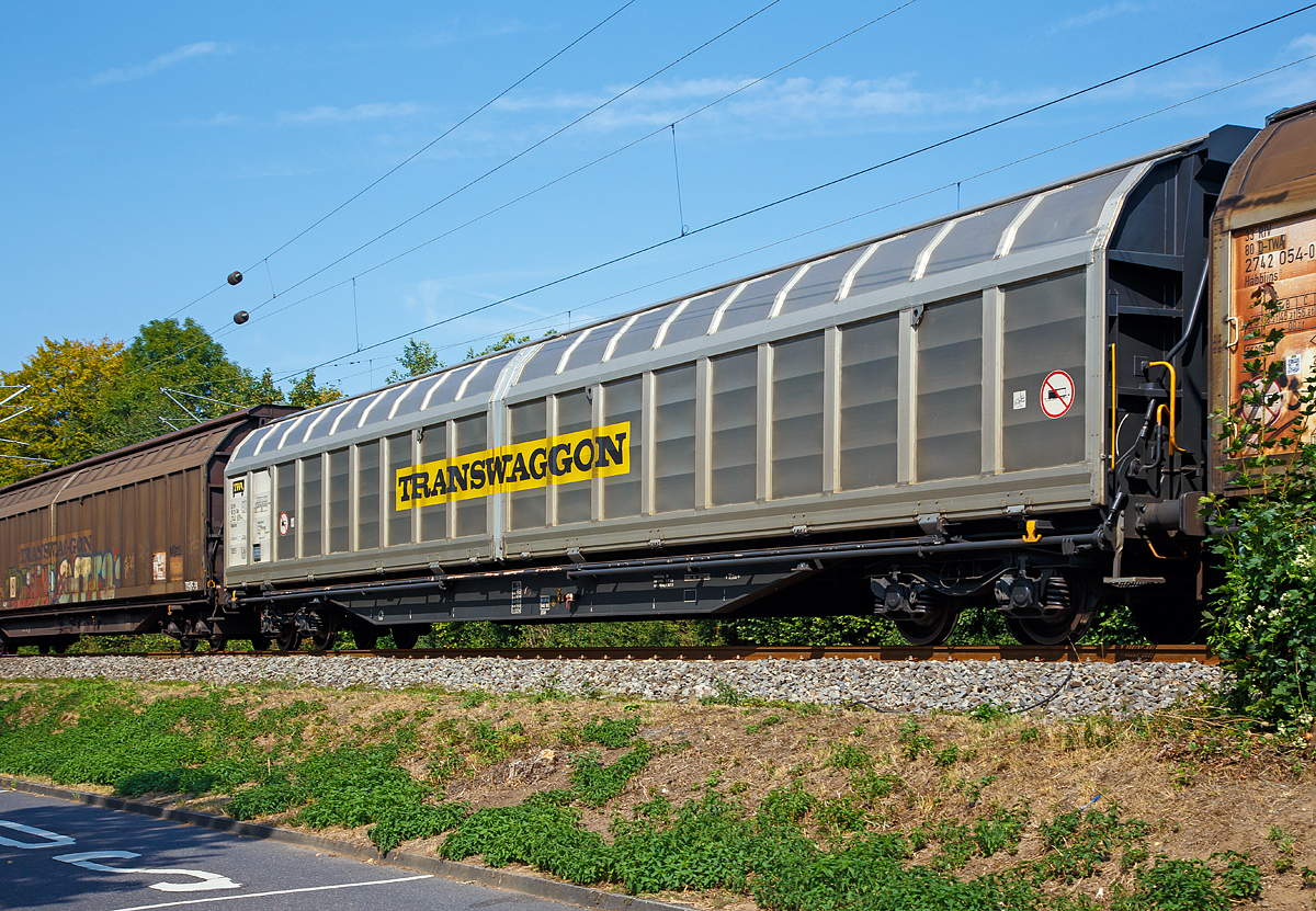 Transwaggon vierachsiger, gro�r�umiger Drehgestell-Schiebewandwagen der Gattung Habbiins 17, 33 85 2740 809-4 CH-TWA, Gattung Habbiins 17, am 28.08.2018 im Zugverband bei Zugdurchfahrt in Bad Honnef.

Diese gro�r�umigen Wagen sind mit Schiebew�nden ausger�stet, die von einer Person bewegt werden k�nnen. Im ge�ffneten Zustand ist der Zugang zur halben Ladefl�che von beiden Seiten m�glich. Das Be- und Entladen mit Gabelstaplern ist damit sowohl von einer Rampe als auch von ebener Erde m�glich. Die Wagen sind f�r eine schonende Bef�rderung hochempfindlicher G�ter verschiedener Art. Er bietet Platz f�r 63 Euro-Paletten (800 x 1.200 mm) oder 42 Industrie-Paletten (1.000 x 1.200 mm).

TECHNISCHE DATEN:
Spurweite: 1.435 mm
Anzahl der Achsen: 4 (in zwei Drehgestellen)
L�nge �ber Puffer: 23.264 mm
Drehzapfenabstand: 17.724 mm
Achsabstand im Drehgestell: 1.800 mm
Ladel�nge: 22.000 mm
Ladebreit: 2.840 mm
Ladefl�che: 62,4 m�
Laderaum: 167 m�
Fu�bodenh�he von SOK:  1.200 mm
Min. befahrbarer Kurvenradius:  R= 60 m
Eigengewicht: 26.000 kg
Max. Ladegewicht: 64,0 t (ab Streckenklasse D)
Maximale Radsatzlast: 22,5 t
Schiebewand�ffnung: 2 x 10.808 mm
H�chstgeschwindigkeit: 100 km/h (beladen) / 120 Km/h (leer)
Bauart der Bremse: KE-GP-A max. 59 t
Verwendungsf�higkeit: RIV
