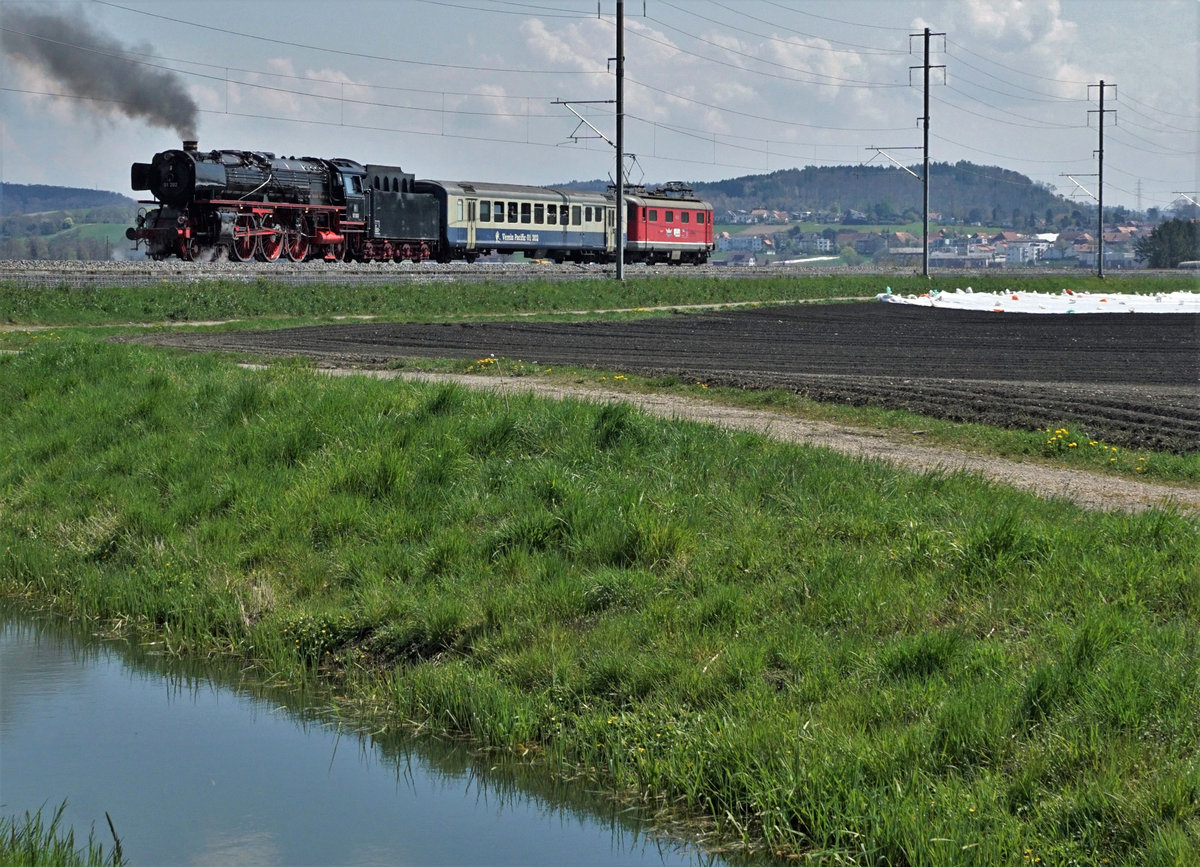 Verein Pacific 01 202.
Nachdem die Trieb- und Kuppelstangen der 01 202 aus Meiningen zurück und wieder montiert sind, fand am 22. April 2021 die geplante Probefahrt rund um den Bielersee statt.
Der Testzug bestand zusätzlich aus der Re 4/4 l 10009, ehemals SBB und einem BD, ehemals BLS.
Bei Kerzers im Seeland der Gemüsekammer der Schweiz.
Foto: Walter Ruetsch