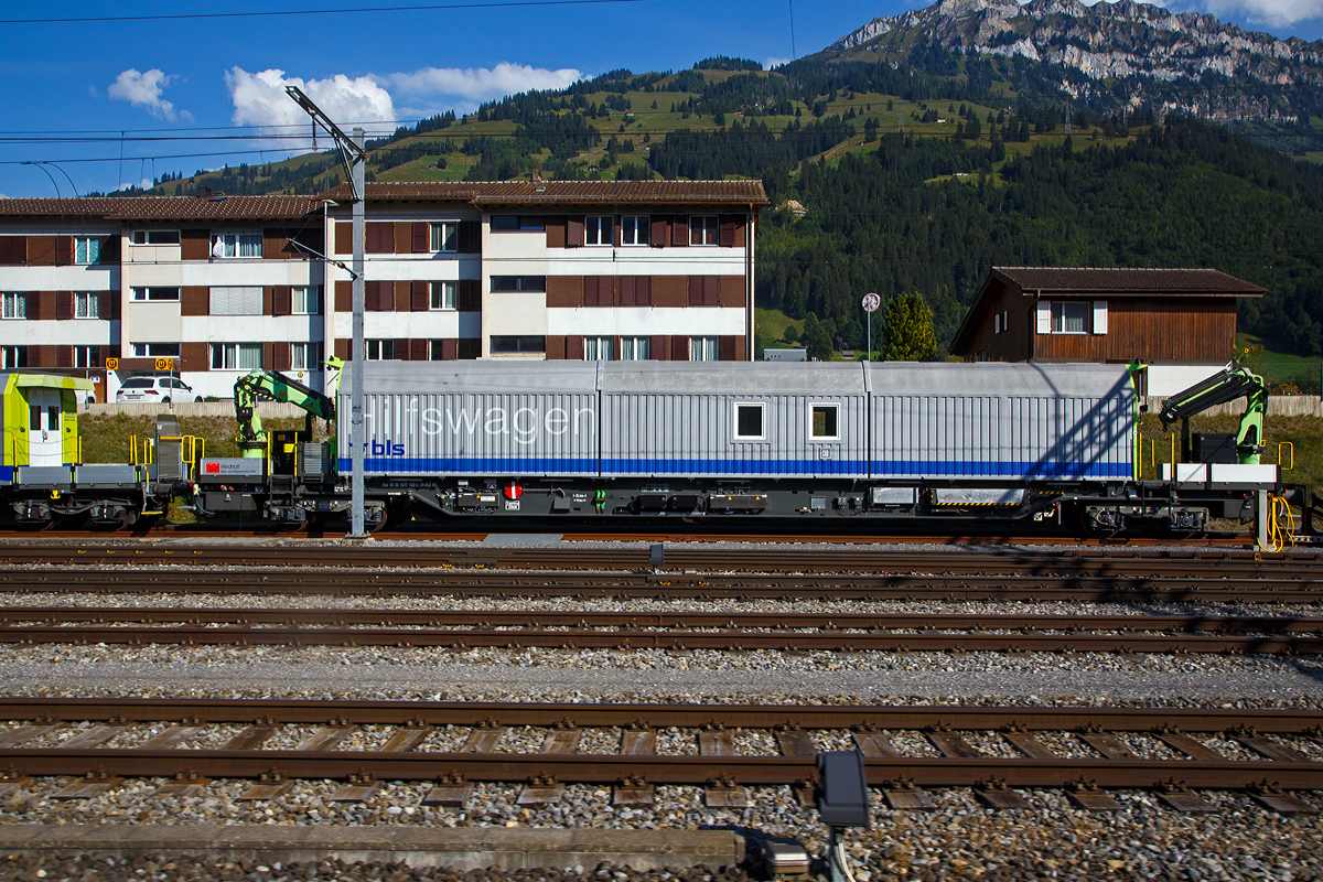 Vierachsiger BLS Hilfswagen (für den Einsatz am Lötschberg-Basistunnel) Xas 99 85 9277 502 – 2 CH-BLSN der BLS Netz AG am 08.09.2021 beim Bahnhof Frutigen (aufgenommen aus einem Zug heraus).

Der Wagen hat zwei hydraulische Ladekrane und ist mit einem Dieselmotor (mit 126 kW Leistung) ausgerüstet und kann mit geringer Geschwindigkeit (bis zu10 km/h) die letzte Wegstrecke in Eigenfahrt zum Einsatzort zurücklegen. Die Anfahrt zum Einsatzort erfolgt im Zugverband. Gebaut wurde zwei dieser Wagen 2004 von Windhoff  Bahn- und Anlagentechnik GmbH in Rheine.

TECHNISCHE DATEN (laut Anschriften):
Spurweite: 1.435 mm (Normalspur)
Länge über Puffer: 26,3 m
Eigengewicht: 74,0 t
Höchstgeschwindigkeit geschleppt: 100 km/h
Max. Ladegewicht: 16 t (ab Streckenklasse D)
