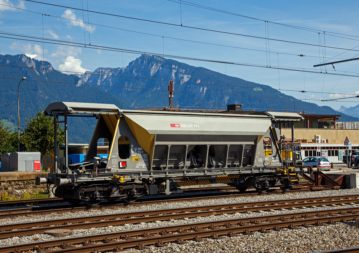 Vierachsiger Drehgestell Schotter-Kieswagen (Planum-Kiessandwagen), Xans 80 85 98 74 704-2 CH-SBBI, der SBB Infrastruktur abgestellt am 08.09.2021 beim Bahnhof Spiez (CH).

Der Wagen hat ein zweiteiliges Schiebedach. Die Entladung erfolgt über zwei Schwingförderrinnen (von KHD Humboldt Wedag) und ein ausschwenkbares Förderband wahlweise nach beiden Wagenseiten. Der Abwurfbereich liegt zwischen 2 m und 4,1 m zur Fahrzeuglängsachse. Die Entladezeit einschließlich Rüstzeit beträgt 8 Minuten. Die 40 m³ Ladegut können in dieser kurzen Zeit aus geringer Fallhöhe in die Baugruppe entleert werden und bei langsamer Geschwindigkeit durch schwenken des Förderbandes auch verteilt werden.

TECHNISCHE DATEN:
Spurweite: 1.435 mm (Normalspur)
Anzahl der Achsen: 4 (in 2 Drehgestellen)
Länge über Puffer: 15.000 mm
Drehzapfenabstand: 9.960 mm
Achsabstand im Drehgestell: 1.800 mm
Laufkreisdurchmesser: 920 mm (neu)
Eigengewicht: 26.700 kg
Max. Nutzlast: 63,3 t ab Streckenklasse D
Zul. Geschwindigkeit: 100 km/h (beladen) / 120 km/h (leer)
Bauart der Bremse: O-GP-A
Bremssohle: (K) C 810 
Handbremse: Ja