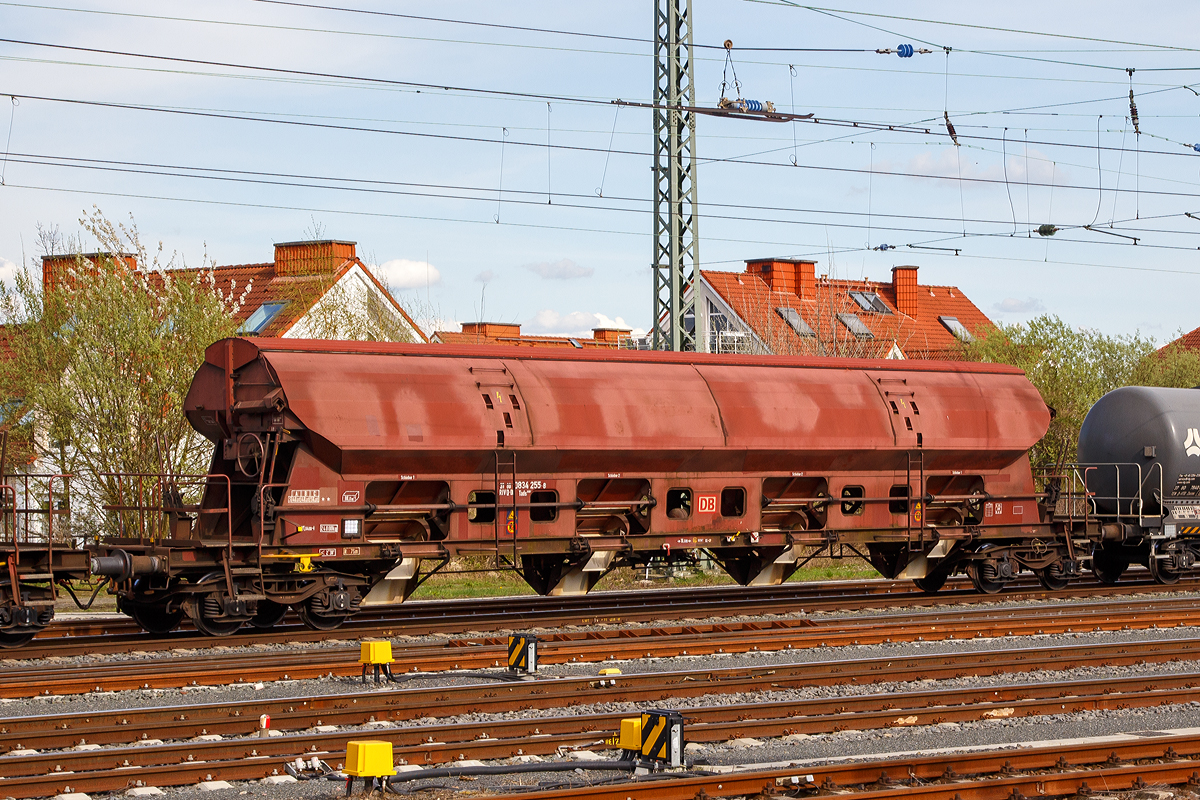 Vierachsiger gedeckter Drehgestell-Sch�ttgutwagen mit dosierbarer Schwerkraftentladung, 31 80 0834 255-8 D-DB, der Gattung Tads 960.1 der DB Cargo am 14.04.2018 im Zugverband bei der Durchfahrt im Bahnhof Friedberg (Hessen).

Diese Wagen sind hervorragend geeignet f�r den Transport von witterungsempfindlichen Sch�ttg�tern, wie z.B. Quarzsand. Sie besitzen eine gleisseitige, dosierbare Entladeeinrichtung. Ein Innenanstrich erh�ht bei den meisten der Fahrzeuge den Gebrauchswert, insbesondere durch den Schutz vor Verunreinigungen, M�glichkeiten des Transportes von Lebensmitteln, g�nstigeres Entladeverhalten (Rutschverhalten) bei schwer flie�enden G�tern sowie durch verbesserten Korrosionsschutz bei aggressiven Ladeg�tern. 

Die Wagen der Bauart Tads 960 sind durch Umzeichnung aus der Bauart Tadgs 959 hervorgegangen. Er eignet sich wegen seiner besonderen Schieberabdichtung f�r den Transport von feink�rnigen, n�sseempfindlichen Sch�ttg�tern, besonders f�r Quarzsand. Der Transport grobk�rniger, kantiger  oder schwerer Sch�ttg�ter (z. B. Kies, Schlacke, Schotter) ist wegen m�glicher Besch�digungen der Innenbeschichtung nicht zul�ssig.

Der Wagen kann wahlweise nach der einen oder anderen Seite oder gleichzeitig nach beiden Seiten entladen werden. Die regelbare Entladung erm�glicht die Beschickung von F�rderb�ndern. Die schwenkbaren Auslaufrutschen gestatten den Einsatz des Wagens f�r die Entladung in Bunkern oder auf seitliche F�rderb�nder.

Das Untergestell ist aus Walzprofilen (aus St 52-3, heute S 355) geschwei�t. Der Wagenkasten ist ebenfalls geschwei�t. F�r die 3 mm dicken Kastenbleche wurde St 52-3 (S 355) mit Cu-Zusatz verwendet.
In jeder Seitenwand sind vier exzentrisch gelagerte Rundschieber angeordnet. Jeder Schieber kann einzeln mit einem Handhebel von der B�hne aus ge�ffnet und geschlossen werden.

Die Unterkanten der festen Auslaufrutschen liegen bei leerem Wagen 720 mm �ber SO. Die Unterkanten der beweglichen Auslaufrutschen liegen bei leerem Wagen im ausgeschwenkten Zustand 385 mm �ber SO. Zum Beladen des Wagens wird das Schwenkdach von der Bedienungsplattform aus mit einem Handrad ge�ffnet. Dabei wird eine �ber die ganze Wagenl�nge reichende �ffnung von 1.200 mm Breite freigegeben. Das ge�ffnete Dach bleibt innerhalb der Wagenbegrenzungslinie, so dass Verschiebebewegungen auch bei ge�ffnetem Schwenkdach m�glich sind.

TECHNISCHE DATEN:
Hersteller:  Talbot
Spurweite: 1.435 mm
Achsanzahl: 4 (in 2 Drehgestelle)
L�nge �ber Puffer: 21.640 mm
Drehzapfenabstand: 16.600  mm
Achsabstand im Drehgestell: 1.800 mm
Wagenh�he: 4.249 mm
Gr��e der Belade�ffnung L�nge x Breite: 16.800 x 1.200 mm
Laderaum:  80,0  m�
Eigengewicht: 24.000 kg
H�chstgeschwindigkeit:  100  km/h (beladen) / 120 km/h (leer)
Maximales Ladegewicht: 56,0 t (Streckenklasse C oder h�her)
Kleinster bef. Gleisbogenradius: 75 m
Bauart der Bremse: KE-GP
Intern. Verwendungsf�higkeit: RIV