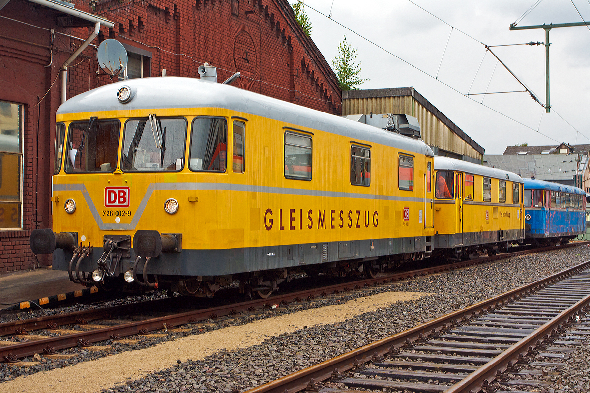 
Von der anderen Seite und Fortsetzung der Beschreibung (siehe Vorgönger Bild)...
Der Gleismesszug 725 002-0 / 726 002-9 der DB Netz Instandhaltung ist am 16.08.2014 im Südwestfälischen Eisenbahnmuseum in Siegen ausgestellt.

Der Messwagen BR 726:
Dieser entspricht in der Grundkonstruktion der Ausführung des Regelturmtriebwagens BR 701. Auf geringer Verwindung und Durchbiegung ist durch Längs- und Querträger mit entsprechenden Widerstandsmomenten besonderer Wert gelegt worden.

Der Gleismesswagen besteht aus dem Messraum und einem Führerstand. In der Mitte des Messraumes befindet sich der Messtisch, an dem die Auswertung der Messergebnisse erfolgt. Eine Werkbank ermöglicht der Bedienungsmannschaft kleinere Reparaturen. Die Stromversorgung der Messeinrichtung erfolgt durch ein 220/380 V-Dieselstromaggregat, das im Triebwagen untergebracht ist. Zur Verständigung mit dem Zugführer im Triebwagen ist eine Wechselsprechanlage vorhanden.

Die Messwagen verfügen über eine spezielle Federung, um den Wagen unabhängig von seiner Beladung und dem Verlauf des Fahrwegs stets waagerecht und in konstanter Höhe über der Schienenoberkante zu halten. Dies ist notwendig, um eine ausreichende Genauigkeit der Messergebnisse sicherzustellen.

Die Messung geschieht  mechanisch, mittel unter dem Wagenkasten angebrachten absenkbaren Achsen. Diese registrieren die Gleisparameter, um sie dann auf dem Messtisch anzuzeigen. Diese mechanische Messtechnik gilt inzwischen als überholt, da digitale Messeinrichtungen mittels Ultraschallprüfung oder Lasertechnik eine höhere Genauigkeit erreichen. Zudem können diese bei höheren Geschwindigkeiten betrieben werden, während die Messgeschwindigkeit der Baureihe 725/726 auf 80 km/h begrenzt ist.

Technische Daten der BR 726:
Spurweite: 1.435 mm (Normalspur)
Laufachsen: 2
Länge über Puffer/Kupplung: 13.400 mm
Breite: 3.000 mm
Achsabstand: 6.000 mm
Laufraddurchmesser:  850 mm 
Eigengewicht: 18 t
Nutzlast: 1,0 t
Zul. Anhängelast:   -
Zur Mitfahrt zugel. Personen: 15
Höchstgeschwindigkeit:  90 km/h

Die Wagen (BR 725 mit BR 726) sind miteinander durch Scharfenbergkupplungen verbunden, an den anderen Enden der Fahrgestelle sind normale Seitenpuffer und Schraubenkupplungen angebracht. 

Der Messzug ist auch für Steilstrecken der DB zugelassen, bei der Talfahrt beträgt dann die zulässige Höchstgeschwindigkeit 25 km/h.
