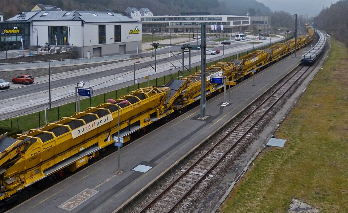 Von der Br�cke �ber dem Bahnhof von Clervaux habe ich den Gleisumbauzug fotografiert, rechts die G�terwagen mit den Betonschwellen. 05.04.2021
Morgen fr�h werden die Wagen noch in die Richtige Reihenfolge gesetzt um danach seine Arbeit zwischen Mecher und Drauffelt der Gleis Erneuerung zu beginnen.
