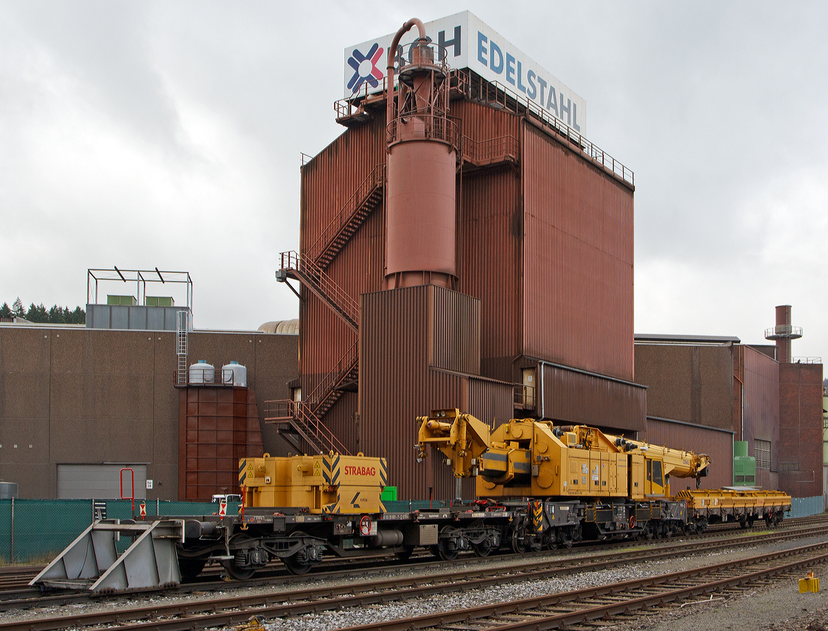 Von der Gegengewichtseite....
Der 150 t Kirow Gleis- und Weichenbaukran KRC 1200+ (ein Kirow MULTI TASKER KRC 1200+) 99 80 9419 005-0 D-STRA  „DONAU“  (ex 97 82 55 508 17-5) der STRABAG RAIL GmbH ist am 25.12.2014 am KSW Bahnhof Siegen-Eintracht (Betriebsbereich Eisern-Siegener Eisenbahn), in Transportstellung abgestellt. 

Vor dem Kran ist der Schutzwagen 99 80 9320 005-8 D-STRA eingestellt, auf diesem befinden sich auch die zugeh. Traversen und Anschlagmittel. Hinter dem Kran ist der Gegenlastwagen 99 80 9320 001-7 D-STRA eingestellt, auf diesem befinden sich die zugeh. Gegengewichte des Kranes. Auf beide Wagen ist zur Achslastreduzierung der Kran mittel Hydraulikzylinder abgest�tzt, auf den Schutzwagen der Kranausleger und auf den Gegenlastwagen der Gegengewichtausleger.

TECHNISCHE DATEN von dem Gegenlastwagen:
Spurweite: 1.435 mm
Eigengewicht: 20.500 kg
Maximale Nutzlast: 59,5 t
Anzahl der Achsen: 4
L�nge �ber Puffer: 12.840 mm
Drehzapfenabstand: 8.000 mm
Achsabstand im Drehgestell: 1.800 mm
Bremse: KE – GPA - K
H�chstgeschwindigkeit: 100 km/h 
Zugelassen f�r Streckenklasse: CE oder h�her
Kleinster befahrbarer Gleisbogen: R = 80 m

Der Gegenlastwagen 2009  von Kirow Ardelt AG in Leipzig unter der Fabriknummer 152600 gebaut.