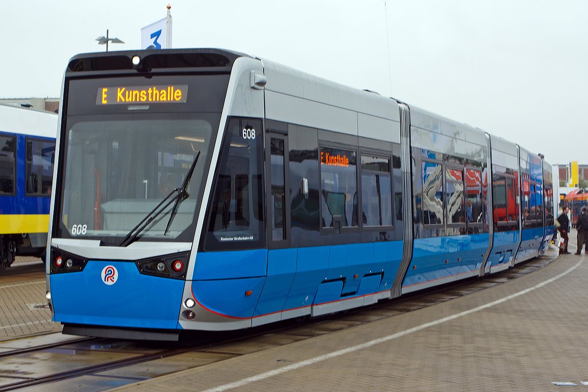 Vossloh Kiepe pr�sentierte auf der InnoTrans 2014 in Berlin (26.09.2014) auf dem Freigel�nde den f�nfteiligen Tramlink 6N2 f�r die Rostocker  Stra�enbahn AG, hier Triebwagen 608.

Die neuen 5-teiligen Multigelenk-Triebfahrzeuge vom Typ Tramlink 6N2 sind 100-prozentigen Niederflurstra�enbahnen, es sind Einrichtungstriebwagen die speziell auf die infrastrukturellen Gegebenheiten und die Charakteristik der Stadt Rostock zugeschnitten wurden.

Dank wassergek�hltem Antrieb und der doppelten Federstufe zwischen den Rads�tzen und den Wagenk�sten sind die Stra�enbahnen sehr leise und vibrationsarm und bieten einen hohen Fahrkomfort. Auf dem Fahrzeugdach befindliche Doppelschichtkondensatoren, sogenannte Supercaps, speichern die beim Bremsvorgang entstehende Energie, um diese anschlie�end wieder zum Anfahren und zur Begrenzung der Anfahrstr�me sowie f�r Heizung und Klimatisierung einzusetzen.

Die Innendecke der Stra�enbahnen ist als zeitloses Fotodesign konzipiert. Durch dieses Fotodesign wird ein luftiges, gro�z�giges Raumgef�hl geschaffen, welches auch bei hohem Fahrgastaufkommen f�r das Auge beruhigende Blickpunkte nach oben bietet. Der Innenraum der Stra�enbahnen wird dadurch optisch vergr��ert.


Technische Daten:
Spurweite: 1.435 mm
Fahrzeugl�nge: 32.000  mm
Fahrzeugbreite: 2.650 mm
Fahrzeugh�he: 3.510 mm
Einstiegsh�he: 290 mm
Anteil Niederflur: 100 %
Leergewicht: 41,8 t
T�ren: 6 (nur an der rechten Fahrzeugseite)
Sitzpl�tze: 71
Stehpl�tze: 139 (4 Pers./m�)
Raddurchmesser:  600 mm (neu) / 520 mm (abgenutzt)
Fahrdrahtspannung:  DC 600 V; umschaltbar auf DC 750 V
Antrieb: 4 x 100 kW
H�chstgeschwindigkeit: 70 km/h
Zulassung: BOStrab
Besonderheiten:  Energiespeicher zur Reduzierung der Anfahrstr�me
