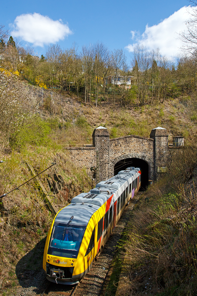 
VT 265 (95 80 0648 165-8 D-HEB /95 80 0648 665-7 D-HEB) der HLB Hessenbahn GmbH (Betreiber der DreiLänderBahn), ein Dieseltriebwagen vom Typ Alstom Coradia LINT 41, kommt hier  gerade am 15.03.2014 aus dem eingleisigen Giersberg-Tunnel (732 m lang).

Er befährt hier die DB Streckennummer 2881 (KBS 445 - Dillstrecke) und erreicht bald den Hbf Siegen.

Über dem hier gezeigten Tunnelportal verläuft die DB Streckennummer 2880 zwischen Siegen-Ost und dem Bahnhof Siegen-Weidenau (rechts liegt der Ausgang vom zweigleisigen 699 m langen Giersbergtunnel). Der Giersbergtunnel wurde 1912 bis 1915 erbaut. Namensgeber ist der 358 Meter hohe Giersberg im östlichen Stadtgebiet von Siegen. Dieser wird vom Giersbergtunnel in zwei getrennten, einander kreuzenden Tunnelröhren durchquert. Die Gleisstrecken der Röhren bilden an zwei getrennten Portalen auf der nordwestlichen Seite des Tunnels den Anschluss an zwei Schenkel eines Gleisdreiecks. Der Giersbergtunnel zählt wegen der einander kreuzenden Röhren zu den Überwerfungsbauwerken und ist der einzige Eisenbahntunnel dieser Bauart in Deutschland. Beide Tunnelstrecken wurden am 1. Dezember 1915 in Betrieb genommen.