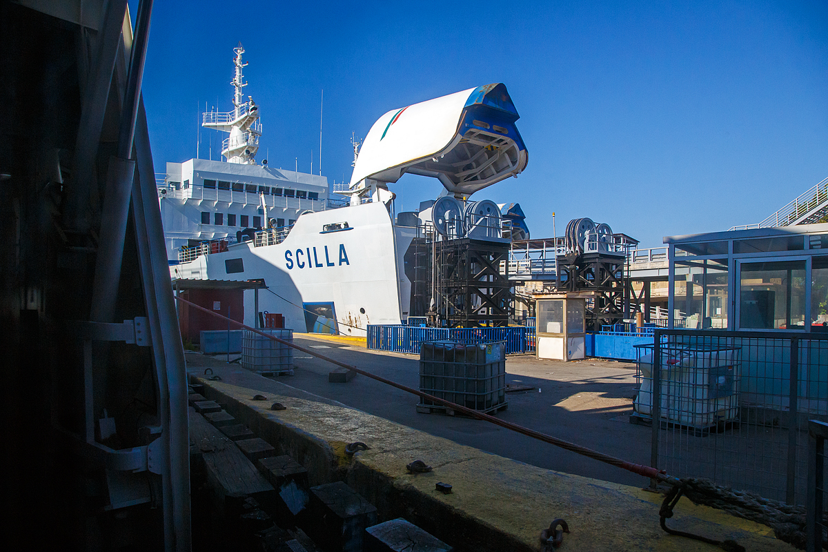 Während unser Trenitalia InterCity Notte ICN 1962, von Syrakus (Siracusa) nach Milano Centrale, am 20.07.2022 in Messina auf die RFI Eisenbahnfähre Iginia II geschoben (Verladen) wird, hat auch die RFI Eisenbahnfähre Scilla die Bugklappe auf und wartet auch auf einen Zug bzw. Eisenbahnwagons.