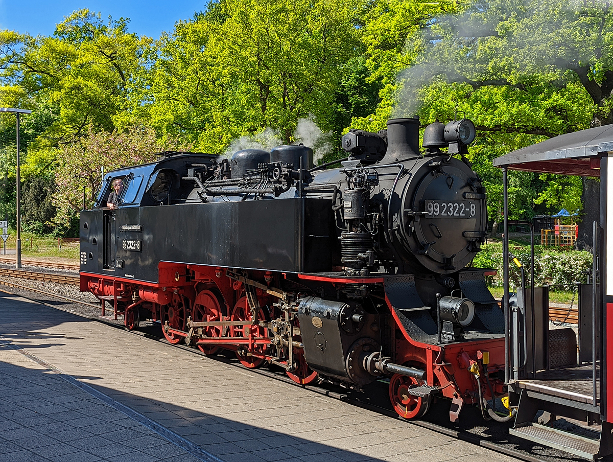 Was heute für Bilder mit dem Smartphone möglich sind....
Die 99 2322-8 der Mecklenburgischen Bäderbahn Molli steht am 15.05.2022 mit dem MBB Dampfzug nach Kühlungsborn-West im Bahnhof Bad Doberan zur Abfahrt bereit.

Die 900 mm-Schmalspur-Dampflok der DR-Baureihe 99.32 wurde1932 von O&K - Orenstein & Koppel AG in Berlin-Drewitz unter der Fabriknummer 12401 gebaut und an die DRG - Deutsche Reichsbahn-Gesellschaft als 99 322, für die Bäderbahn Bad Doberan–Kühlungsborn, geliefert.

Lebenslauf
1932 	bis 1970 DRG, DRB bzw. DR 99 322
01.06.1970 Umzeichnung in DR 99 2322-8 
01.01.1992 Umzeichnung in DR 099 902-9
01.01.1994 DB 099 902-9 
Seit dem 04.10.1995 Mecklenburgische Bäderbahn Molli GmbH, Bad Doberan MBB 99 2322-8

Die Fahrzeuge der Baureihe 99.32 der Deutschen Reichsbahn sind nach den Einheitsgrundsätzen gebaute Schmalspur-Lokomotiven für die Spurweite von 900 mm. Die 1932 für die Bäderbahn Bad Doberan - Kühlungsborn beschafften drei Lokomotiven sind bis heute im Einsatz und werden durch eine 2009 von dem Dampflokwerk Meiningen nachgebaute Lokomotive dabei ergänzt.

Das steigende Verkehrsaufkommen auf der Bahnstrecke zwischen Bad Doberan und Kühlungsborn führte die 1923 beschafften Lokomotiven der Baureihe 99.31 an ihre Leistungsgrenze. Die Deutsche Reichsbahn bestellte deshalb bei Orenstein & Koppel drei Lokomotiven der Bauart 1'D1' h2 zur Erweiterung des Fahrzeugparks. Dabei sollte sich das Unternehmen bei der Konstruktion an die Baugrundsätze und Normen der Einheitslokomotiven orientieren. Ursprünglich waren die Lokomotiven im Typen-Programm nicht vorgesehen. Die Verwendung vieler standardisierter Baugruppen erlaubt jedoch die Verwendung des Begriffs Einheitslokomotive. Die drei Lokomotiven wurden 1932 ausgeliefert. Zur Verkürzung der Reisezeit wurden die Fahrzeuge für eine Geschwindigkeit von 50 km/h ausgelegt. Damit sind sie neben der NWE Nr. 21 (HSB 99 6001) die einzigen deutschen Schmalspurdampflokomotiven mit einer solchen Höchstgeschwindigkeit.

Mit der Einführung der EDV-Nummern erhielten die Lokomotiven 1970 die neue Loknummern 99 2321-0, 99 2322-8 und 99 2323-6. In der Mitte 1970er Jahre erhielten die 99 2322 und 99 2323 geschweißte Stahlzylinder statt der abgenutzten Graugusszylinder. Bei der 99 2321 erfolgte der Tausch Ende der 1980er Jahre. Mit der Einführung des Nummernschemas der Deutschen Bundesbahn zum 1. Januar 1992 erhielten die Lokomotiven die Betriebsnummern 099 901-1, 099 902-9 und 099 903-7. Mit der Betriebsübernahme der Mecklenburgischen Bäderbahn Molli GmbH & Co. KG zum 1. Oktober 1995 kamen die Lokomotiven zu dieser Gesellschaft und erhielten ihre vorherigen EDV-Nummern zurück.

Zwischen 1994 und 1997 wurden alle Lokomotiven im Dampflokwerk Meiningen einer Generalinstandsetzung unterzogen. Dabei erhielten die Lokomotiven geschweißte Kessel, neue Wasserkästen und Radreifen. Bei der Hauptuntersuchung im Zeitraum 2003 bis 2006 erhielten die Lokomotiven neue geschweißte Blechrahmen. An der 99 2322-6 erprobte man von 2003 bis 2006 Rollenachslager. Diese bewährten sich jedoch nicht.

Da die noch betriebsfähige Lokomotive der Baureihe 99.33 (99 331) den Anforderungen des Sommerfahrplans nicht gewachsen ist, aber eine weitere leistungsfähige Lok benötigt wurde, entschloss man sich, eine Lokomotive der Baureihe 99.32 auf der Basis der bisherigen konstruktiven Verbesserungen nachzubauen. Die im Dampflokwerk Meiningen hergestellte Lokomotive 99 2324-4 wurde 2009 in Dienst gestellt.

Konstruktive Merkmale:
Abweichend von den Bauprinzipien der Einheitslokomotiven verfügten die Lokomotiven über einen genieteten Blechrahmen mit Längs- und Querversteifungen statt eines Barrenrahmens. Seit der von 2003 bis 2006 durchgeführten Hauptuntersuchung besitzen die Lokomotiven einen geschweißten Blechrahmen.

Der genietete Langkessel besteht aus zwei Schüssen. Der Dampfdom mit dem Schmidt & Wagner-Nassdampfregler sitzt auf dem zweiten Schuss, während der Sandkasten auf dem ersten sitzt. Der für Nass- und Heißdampf getrennte Dampfsammelkasten befindet sich in der Rauchkammer. Beim Rauchrohrüberhitzer verwendet man einen ungewöhnlichen Rohrspiegel. Vier Heizrohren stehen 69 Rauchrohre gegenüber. Die Ackermann-Sicherheitsventile sitzen auf dem Stehkesselscheitel. 1994 bis 1997 erhielten die Lokomotiven neu konstruierte geschweißte Stahlkessel.

Das außenliegende waagerecht angeordnete Zweizylinder-Heißdampftriebwerk arbeitet auf die dritte Kuppelachse. Die ursprünglichen Graugusszylinder wurden ab Mitte der 1970er Jahre durch geschweißte Stahlzylinder ersetzt. Die außenliegende Heusinger-Steuerung besitzt eine Kuhnsche Schleife. Die ursprünglichen Regelkolbenschieber wurden später durch Müller-Druckausgleich-Kolbenschieber ersetzt. Heute kommen Trofimoff-Schieber der Bauart Görlitz zur Anwendung.

Das Laufwerk ist an vier Punkten abgestützt. Die Blattfederpakete der Kuppelradsätze liegen unterhalb der Achslager. Die Laufradsätze werden oberhalb der Achslager abgefedert. Die Federn der beiden äußeren Radsätze sowie des benachbarten Laufradsatzes sind jeweils durch Ausgleichshebel verbunden. Die Laufradsätze sind als Bisselachsen mit 20 mm Seitenverschiebbarkeit ausgelegt. Die dritte Kuppelachse hat eine Spurkranzschwächung.

Als Lokomotivbremse dient eine Knorr-Zweikammer-Druckluftbremse. Alle Kuppelräder werden von vorn gebremst. Die Luftpumpe befindet sich rechts neben der Rauchkammer. Die Luftbehälter befinden sich auf beiden Seiten unter dem hinteren Wasserkasten.

Die Borsig-Druckluftsandeinrichtung sandet bei Vorwärtsfahrt die ersten beiden Radsätze und bei Rückwärtsfahrt die zweite und dritte Achse. Zur besseren Sicherung der Zugfahrt verfügten die Maschinen über ein Knorr-Druckluftläutewerk vor dem Schornstein und auf dem Kohlekasten. Wegen Lärmbeschwerden der Anwohner bei der Stadtdurchfahrt von Bad Doberan wurde das hintere Läutewerk später entfernt. Ein Dampfturbogenerator hinter dem Schornstein erzeugt eine Leistung von 5 kW bei 85 V. Die Lokomotive verfügt über eine Dampfheizungsanlage.

Das Kesselwasser ist in Wasserkästen vor dem Führerhaus entlang des Langkessels untergebracht. Der Kohlevorrat befindet sich in einem Kohlekasten hinter dem Führerhaus.

Auf Grund des eingeschränkten Lichtraumprofils musste der obere Teil des Führerhauses stark abgeschrägt werden.

TECHNISCHE DATEN:
Anzahl: 	4
Hersteller: Orenstein & Koppel, DLW Meiningen
Baujahre: 1932, 2008
Bauart: 1’D1’ h2t
Gattung: K 46.8
Spurweite: 	900 mm
Länge über Puffer: 10.595 mm
Höhe: 3.400 mm
Gesamtradstand: 8.075 mm
Leergewicht: 35,15 t
Dienstgewicht: 43,68 t
Höchstgeschwindigkeit: 50 km/h
Indizierte Leistung: 460 PSi / 338 kW
Anfahrzugkraft: 59,33 kN
Kuppelraddurchmesser: 1.100 mm
Laufraddurchmesser: 550 mm (vorn und hinten)
Steuerungsart: 	Heusinger außenliegend
Zylinderanzahl: 	2
Zylinderdurchmesser: 380 mm
Kolbenhub: 550 mm
Kesselüberdruck: 14 bar
Anzahl der Heizrohre: 4
Anzahl der Rauchrohre: 69
Heizrohrlänge: 3.500 mm
Rostfläche: 1,60 m²
Strahlungsheizfläche: 5,80 m²
Rohrheizfläche: 54,74 m²
Überhitzerfläche: 30,60 m²
Verdampfungsheizfläche: 60,54 m²
Wasservorrat: 4,25 m³
Brennstoffvorrat: 1,7 t Kohle
Lokbremse: Knorr-Zweikammer-Druckluftbremse
Zugheizung: Dampf
