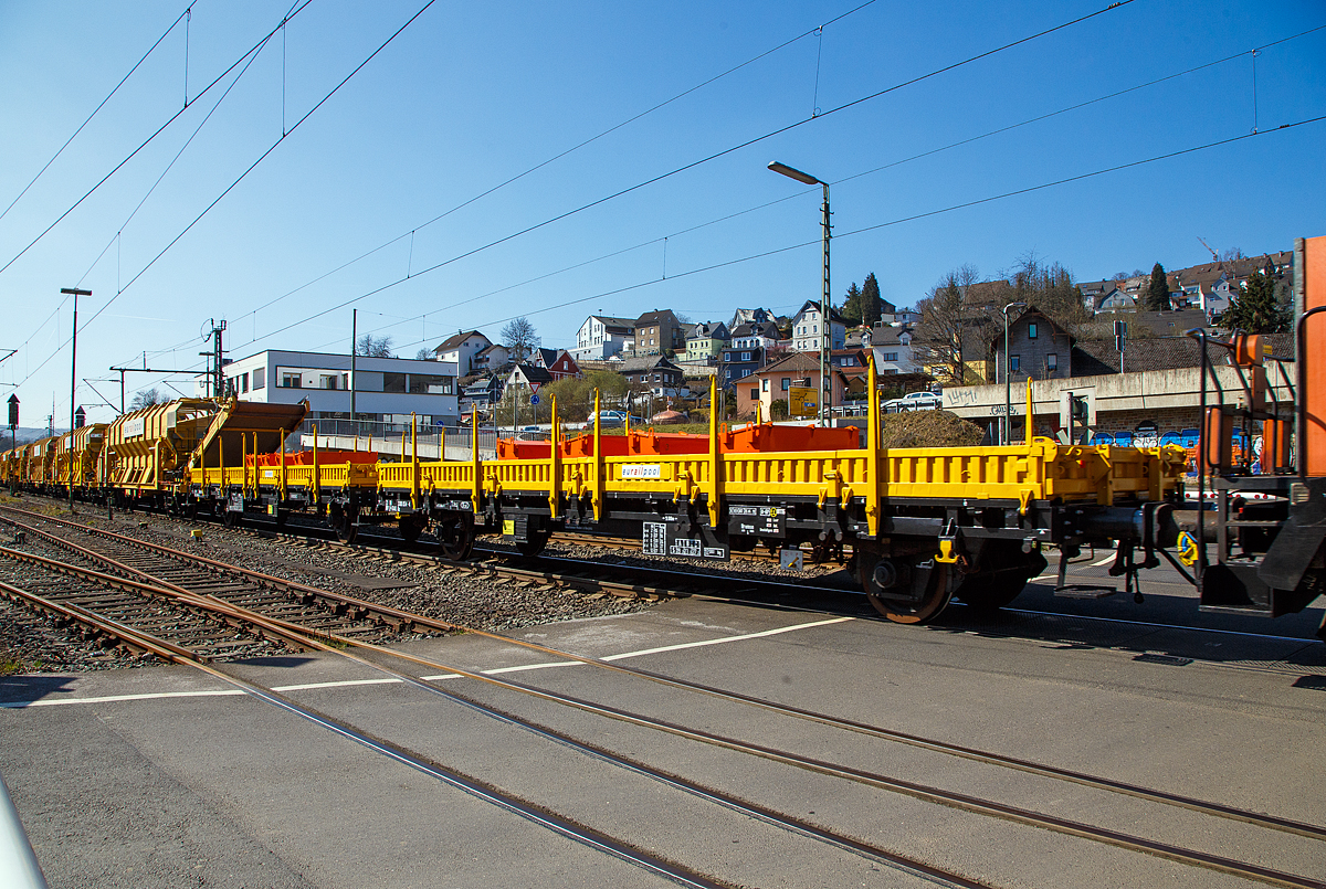 Zwei 2-achsige Flachwagen mit Seiten- und Stirnwandklappen sowie Seitenwandrungen, 23 80 3300 054-4 D-ERAIL und dahinter 23 80 3300 056-9 D-ERAIL, der Gattung Ks, der Eurailpool GmbH, als Schutzwagen zu den Material-Förder- und Siloeinheiten MSF-40, hier am 24.03.2021 bei der Zugdurchfahrt in Niederschelden (Sieg) beim Bü 343 (Km 112,183 der Siegstrecke KBS 460).

Diese Wagen waren früher für den Transport von Walzwerkerzeugnissen, Baufertigteilen, Schüttgütern, sperrigen Gütern und Straßenfahrzeugen vorgesehen. Der Wagenkasten besteht aus 12 stählernen Seiten- und 2 stählernen Stirnborden mit 12 austauschbaren Seitenwanddrehrungen. Die Borde sind so ausgelegt, dass im abgeklappten Zustand ein unbehindertes Befahren des Wagens von Seiten- und Kopframpen aus möglich ist. Der Wagenboden besteht aus 70 mm dicken Holzbohlen. Bei abgeklappten Endseitenborden ist der Güterwagen nicht profilfrei.

TECHNISCHE DATEN eines Wagens:
Spurweite: 1.435 mm
Achsanzahl: 2
Länge über Puffer: 13.860 mm
Achsabstand: 9.000 mm
Laufraddurchmesser: 1.000 mm (neu)
Länge der Ladeflächen: 12.500 mm
Ladefläche: 35,5 m²
Höchstgeschwindigkeit: 100 km/h
Eigengewicht: 12.960 kg
max. Zuladung: 27.000 kg (ab Streckenklasse C)
Kleinster bef. Gleisbogenradius: 35 m
Bauart der Bremse: KE-GP (LL)
Bremssohle: IB 116
Handbremse: nein
Intern. Verwendungsfähigkeit: RIV