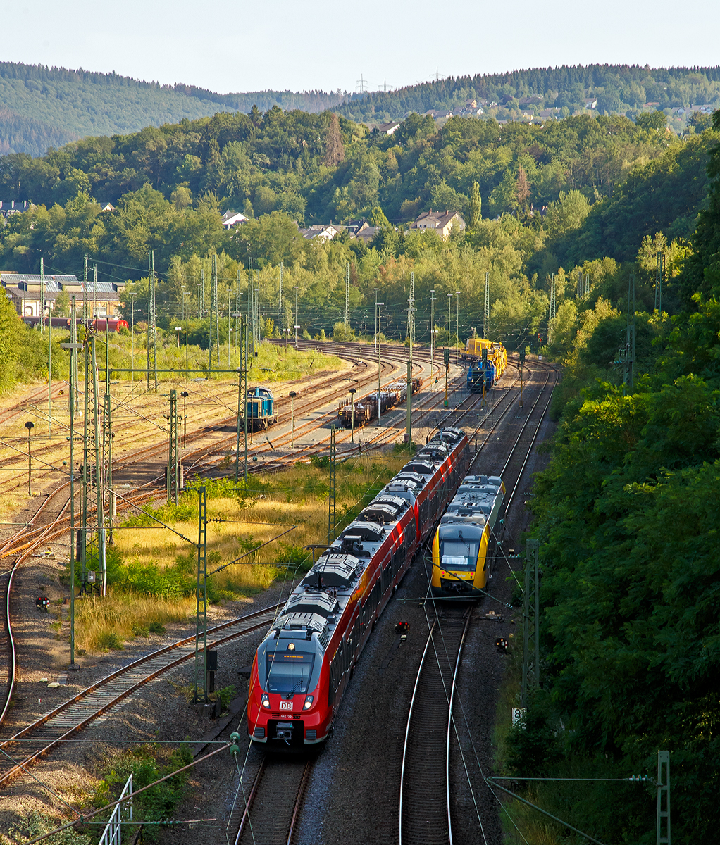 
Zwei gekuppelte Bombardier Talent 2 der DB Regio NRW verlassen am 25.07.2019, als RE 9 - Rhein Sieg Express (RSX) Siegen - Köln - Aachen, mit über 30 Minuten Verspätung Betzdorf (Sieg). Während der Alstom Coradia LINT 41 der HLB (Hessische Landesbahn) VT 257 (95 80 0648 157-5 D-HEB / 95 80 0648 657-4 D-HEB) als RB 90  Westerwald-Sieg-Bahn  (Westerburg - Altenkirchen - Au/Sieg - Siegen) pünktlich Betzdorf (Sieg) erreicht. 

Links in Rangierbahnhof (Rbf Betzdorf) ist eine V 100 abgestellt und nach Tankpause wartet im Doppelpack die V100-SP-028 (92 80 1214 018-4 D-SLG)  und die V100-SP-026 (92 80 1214 016-8 D-SLG) der SLG - Spitzke Logistik GmbH mit der Spitzke Bettungsreinigungsmaschine RM 900 S auf freies Signal zur Weiterfahrt in Richtung Köln.
