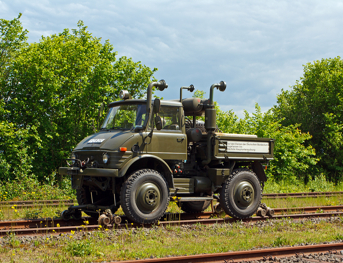 Zweiwege-Fahrzeug UNIMOG 406 ZW 82S der Bundeswehr am 18.05.2014 ausgestellt beim Erlebnisbahnhof Westerwald der Westerw�lder Eisenbahnfreunde 44 508 e. V. in Westerburg, hier war Museumstag. Dank nochmals an das freundliche Museumspersonal.

Zweiwege-Fahrzeuge bilden bei geringem Verkehrsaufkommen eine kosteng�nstige Alternative zu Kleinlokomotiven. Der Bediener muss kein ausgebildeter Lokomotivf�hrer sein und die Infrastruktur ist weniger aufw�ndig, da f�r eine gesch�tzte Unterbringung des Fahrzeuges kein Lokschuppen erforderlich ist. Eine Abl�sung von Lokomotiven der Bundeswehr sollte daher durch die Beschaffung von Zweiwege-Fahrzeugen erfolgen. Man verfolgte anf�nglich den Gedanken, auf die in gro�er Anzahl vorhandenen UNIMOG-Fahrzeuge der Bundeswehr zur�ck zu greifen. Diese sollten im Bedarfsfall von der Truppe mit Hilfe von R�sts�tzen zu Zweiwege-Fahrzeugen umgebaut werden. Jedoch erkannte man sehr schnell, dass dies kein Unterfangen f�r die Fahrbereitschaften war.

Um den kurzfristigen Bedarf bei Standort - Verwaltungen zu decken, orderte die Wehrverwaltung kurzerhand zwei Fahrzeuge. Das Bundesamt f�r Wehrtechnik und Beschaffung kaufte nach ausf�hrlicher Erprobung 1980 insgesamt sechs Zweiwege-Fahrzeuge vom Typ U 406 ZW 82 von der Firma Zweiweg, Rosenheim. Die Fahrzeuge erhielten die Versorgungsnummer 2210-12-183-3328

Das vom  Museum ausgestellte Fahrzeug Y-218 252 stammt aus dem Ger�tehauptdepot Homburg / Saar, zuvor war es von 1981 bis 1996 im Ger�tehauptdepot Worms und hat �ber 35 Jahre seine Aufgaben erf�llt. Es ist betriebsf�hig und wurde von den Westerburger Eisenbahnfreunden mit eigener Kraft auf der Stra�e zum Erlebnisbahnhof Westerburg �berf�hrt. Nach einer technischen �berpr�fung erhielt es eine neue Lackierung im Originalfarbton  NATO - oliv . Es ist eine Leihgabe und Eigentum vom Milit�rhistorisches Museum Dresden.


Der UNIMOG wird angetrieben von einem 80 PS starkem 6-Zylinder-4-takt-Dieselmotor vom Typ Mercedes-Benz OM 352. Dessen Kraft wird �ber eine Wandler-Schaltkupplung sowie �ber ein Synchrongetriebe mit 8 Vorw�rts- und 4 R�ckw�rtsg�nge �bertragen. Die Zusatzausstattung besteht aus einer Eisenbahn-Waggonbremsanlage mit zwei Zusatzkompressoren, 24V-Signal-, Licht- und Warnanlage, dem hochgezogenen Auspuff, sowie pneumatischer Kuppelstange mit Federbeinen.

Technische Daten:
Dienstgewicht: 6.300 kg
H�chstgeschwindigkeit: 70 km/h
Anfahrzugkraft: 3.000 kg/ 29,5 kN
Leistung: 80 PS bei 2.550 U/min
